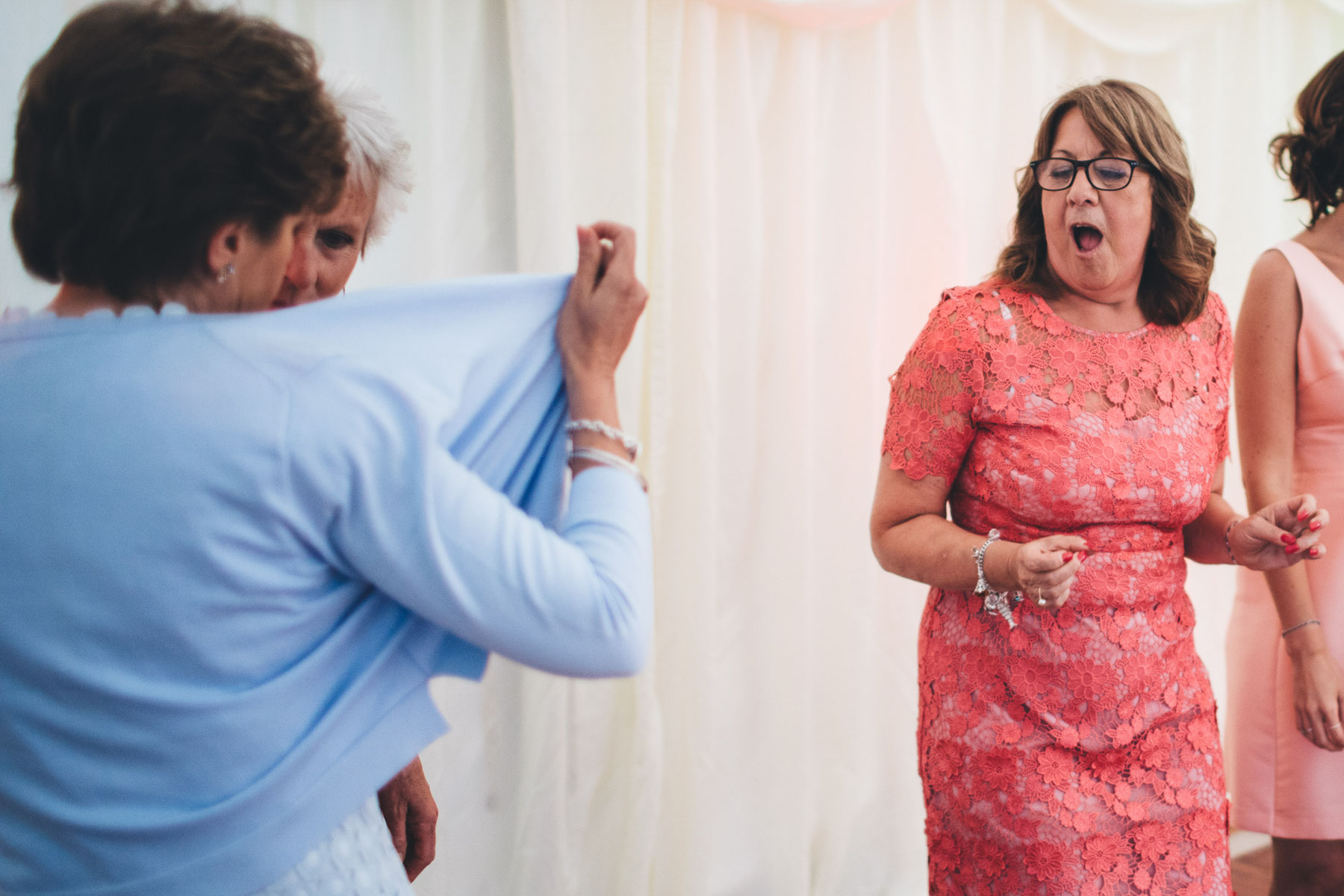 women hold open her shirt as onlooker is shocked