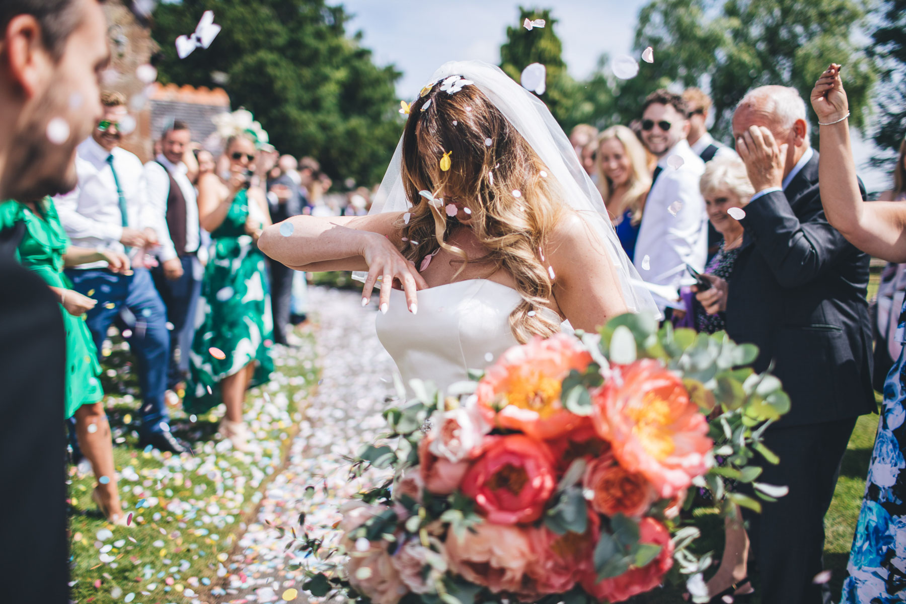 bride looks down her wedding dress for confetti