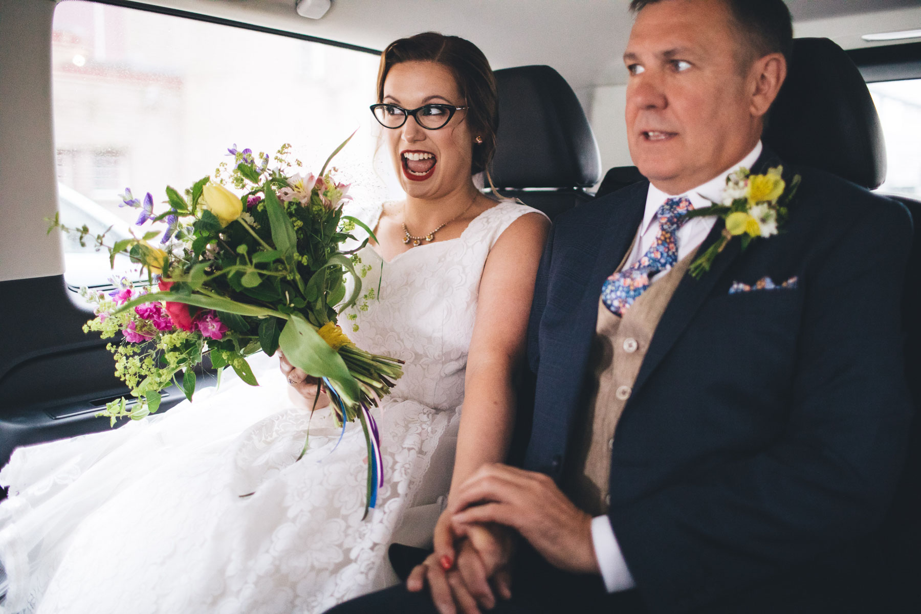 bride looks excited as she arrives with her dad at the wedding