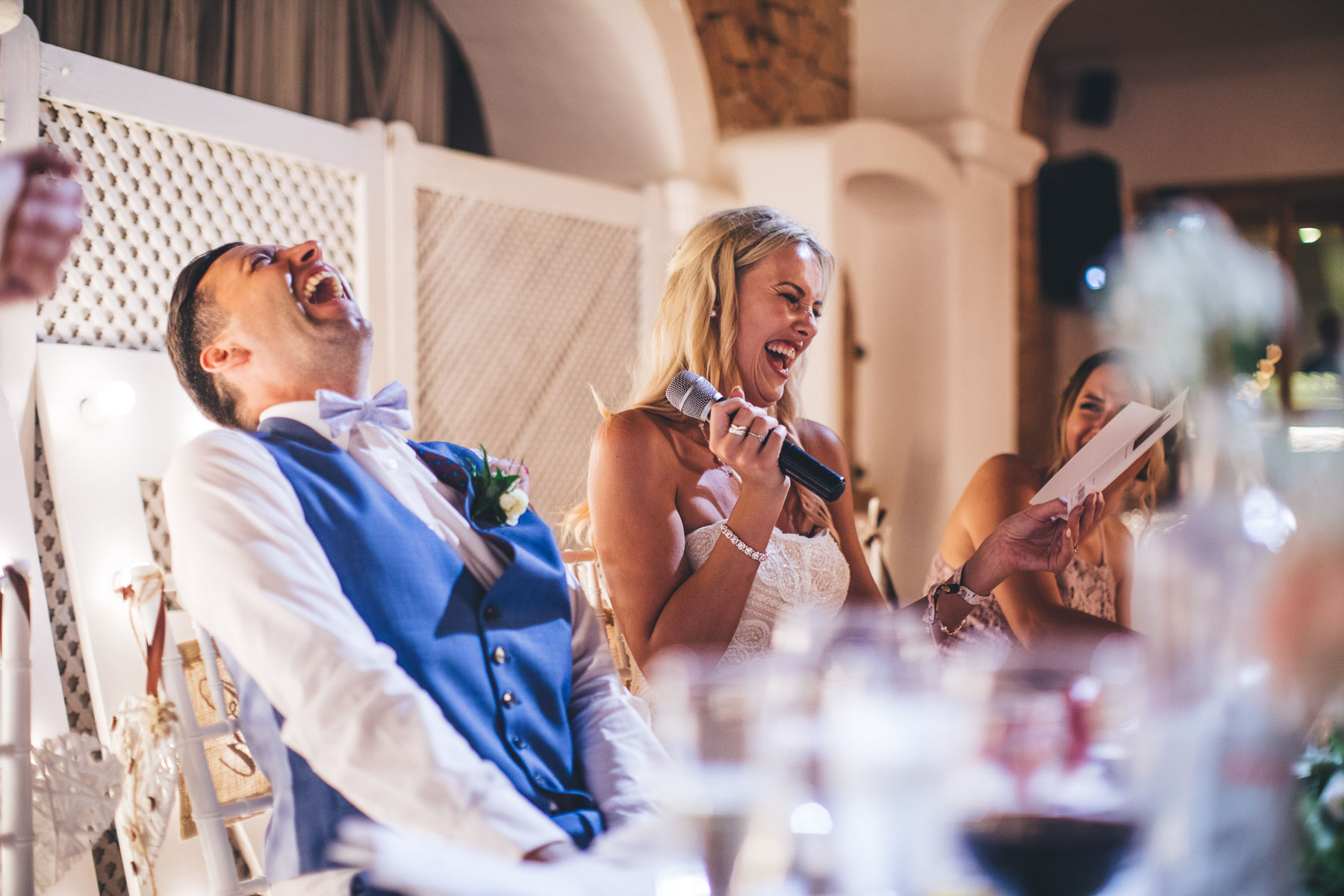 bride and groom laugh during the speeches