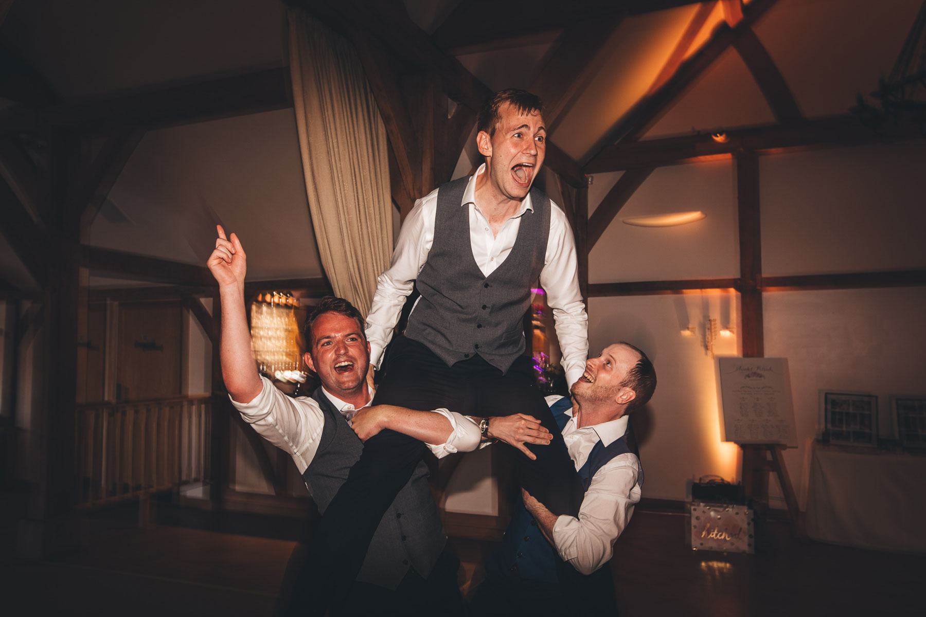 friends pick up the groom and raise him up