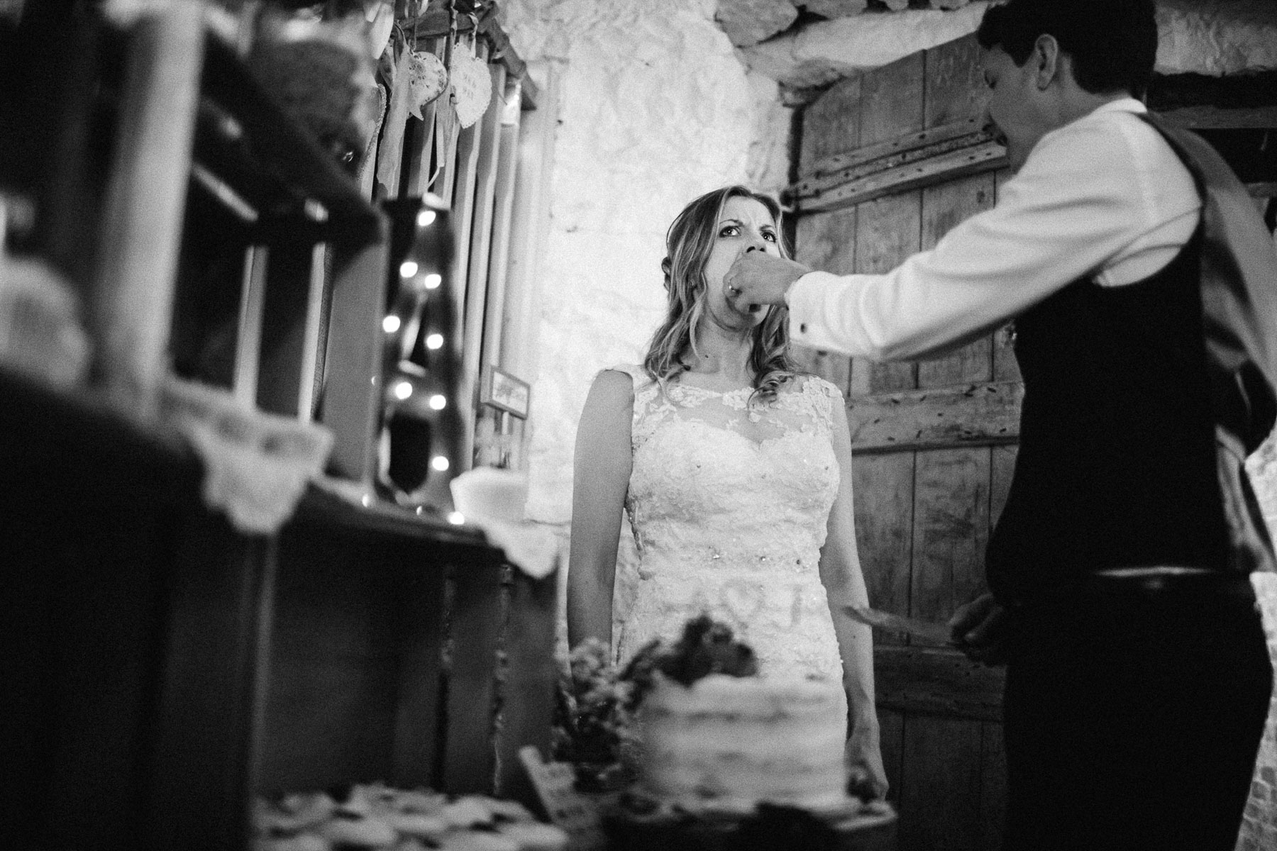 groom feeds his bride cake