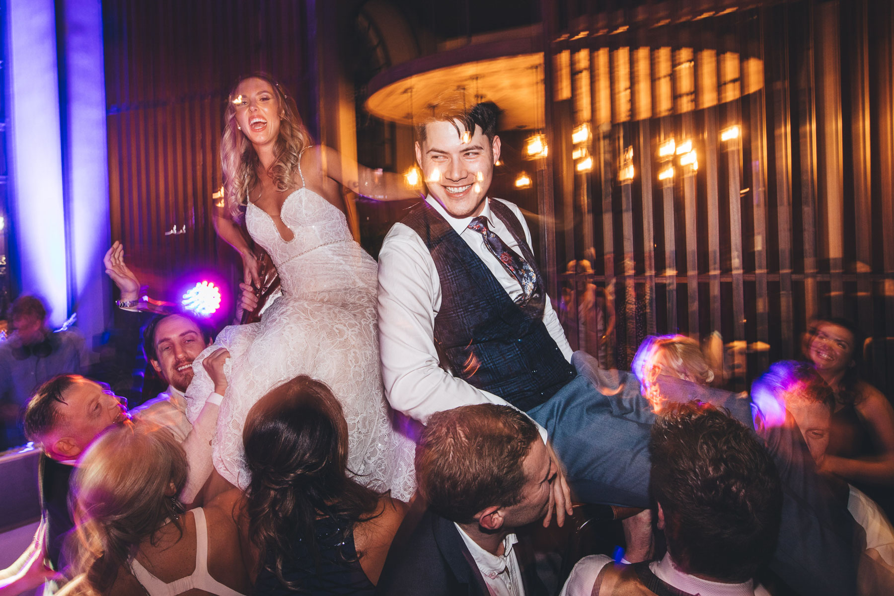 couple raised up over guests on their chairs