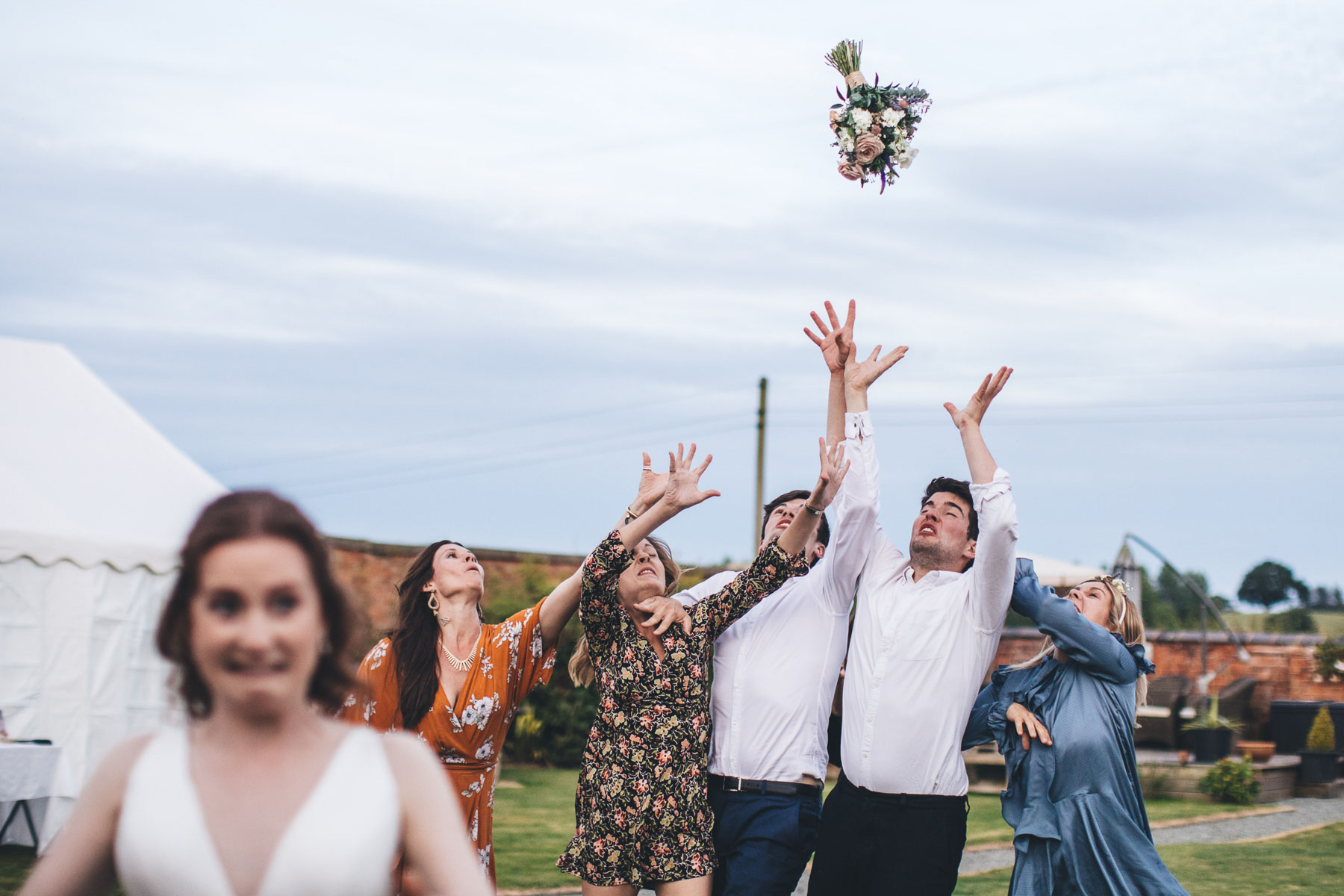 guests try to catch the wedding bouquet