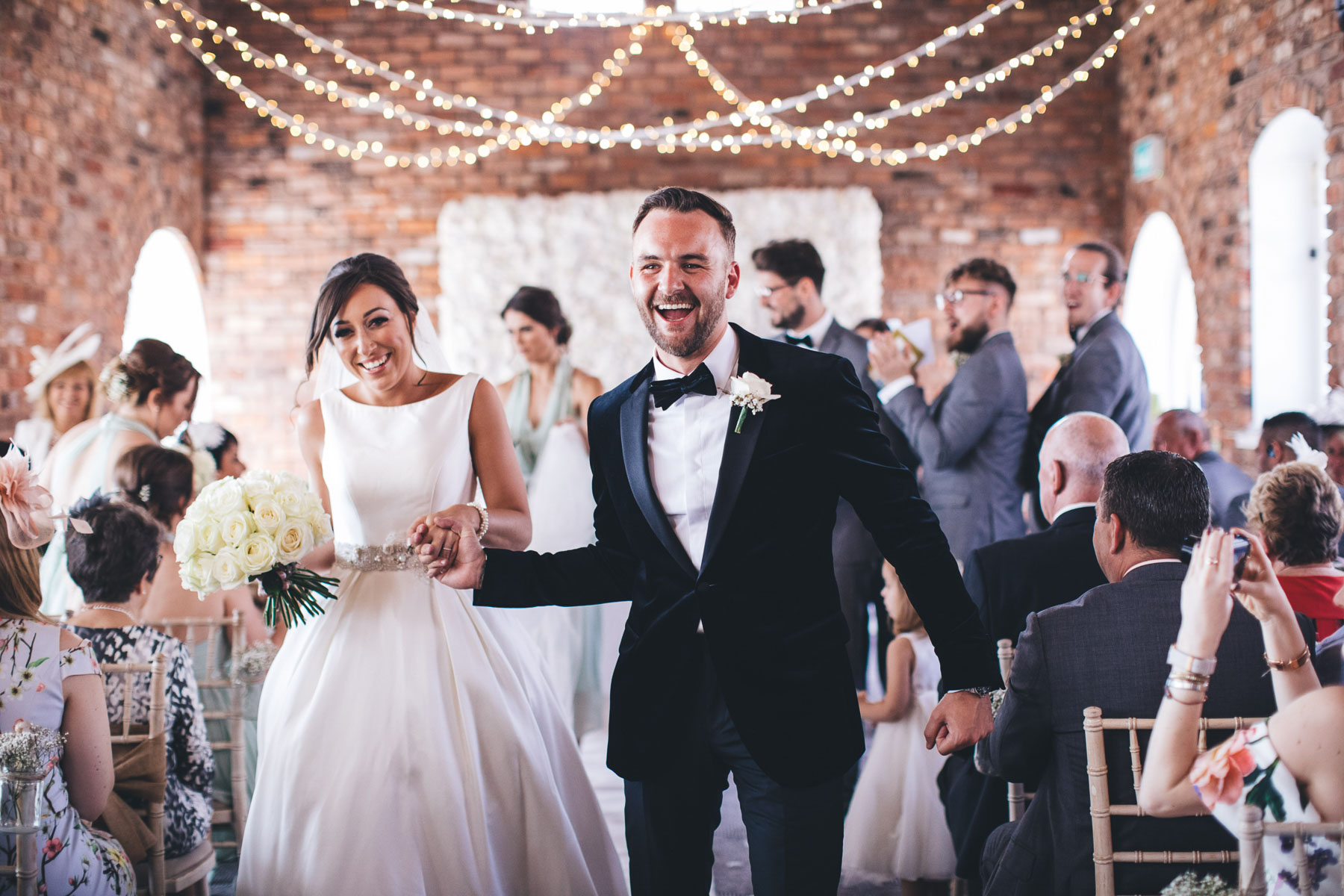 couple walk down the aisle very happy after their wedding ceremony