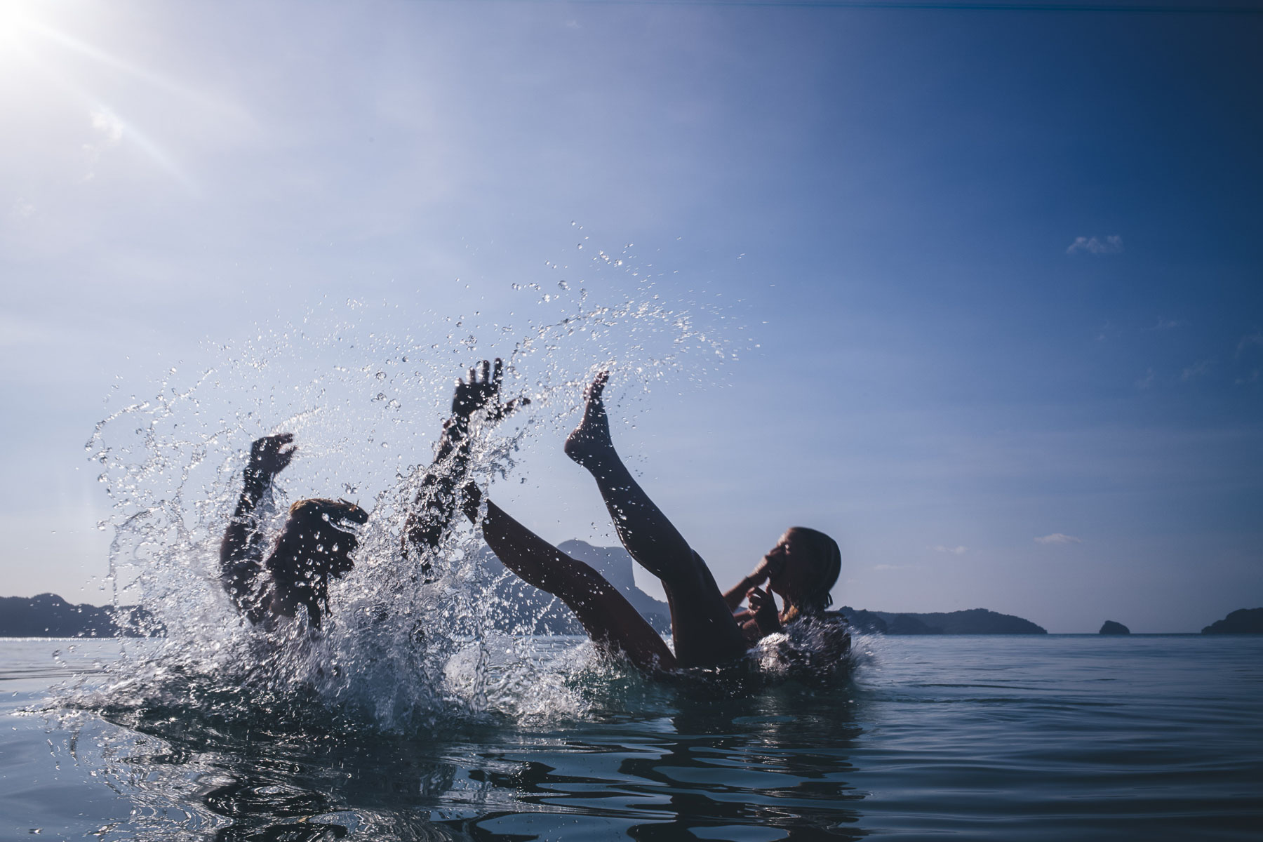 couple fall off backwards in the sea