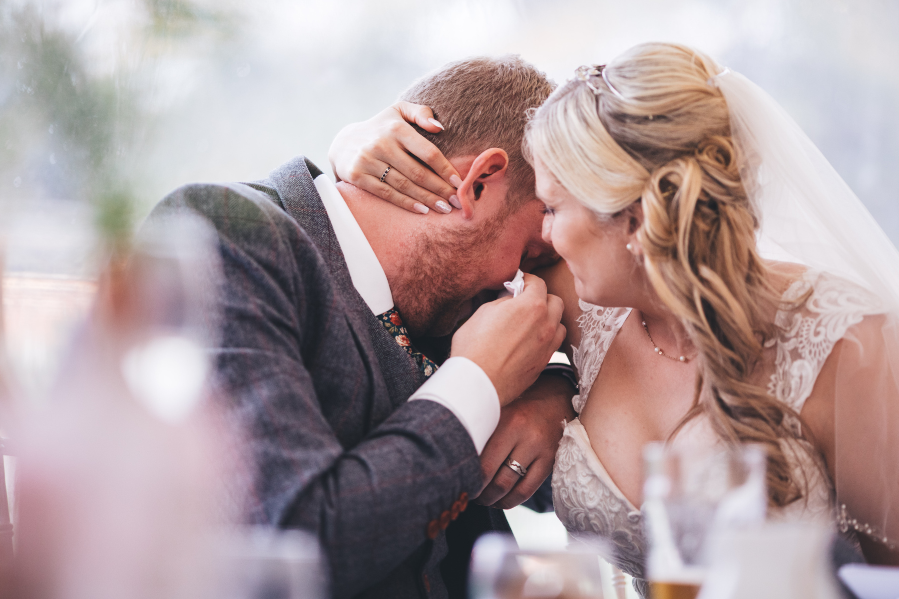 emotional groom consoled by his bride during the speeches