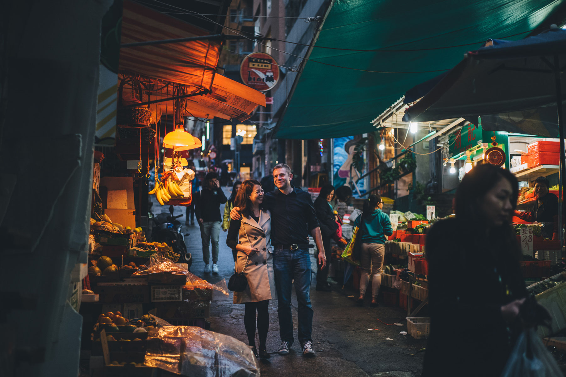 couple walk through the markets of Hong kong