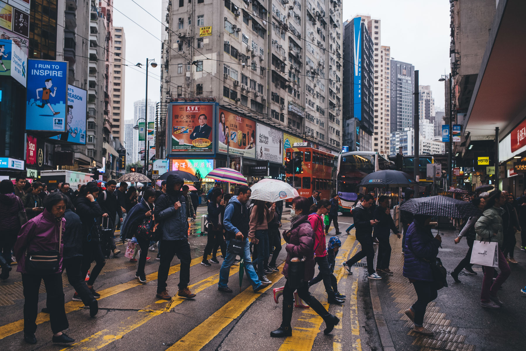 people crossing the street n the rain in hong kong