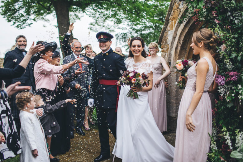 military groom and bride leave church after wedding ceremony