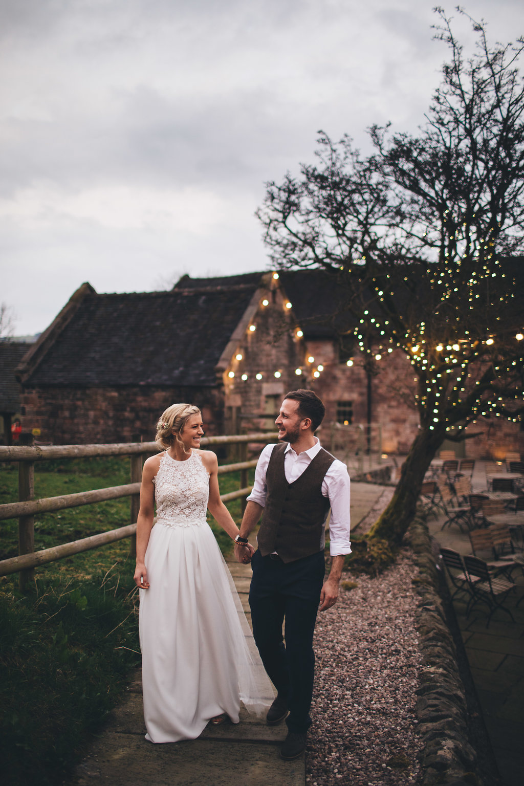 Couild hold hands in romantic portrait under festoon lights by manchester wedding photographer