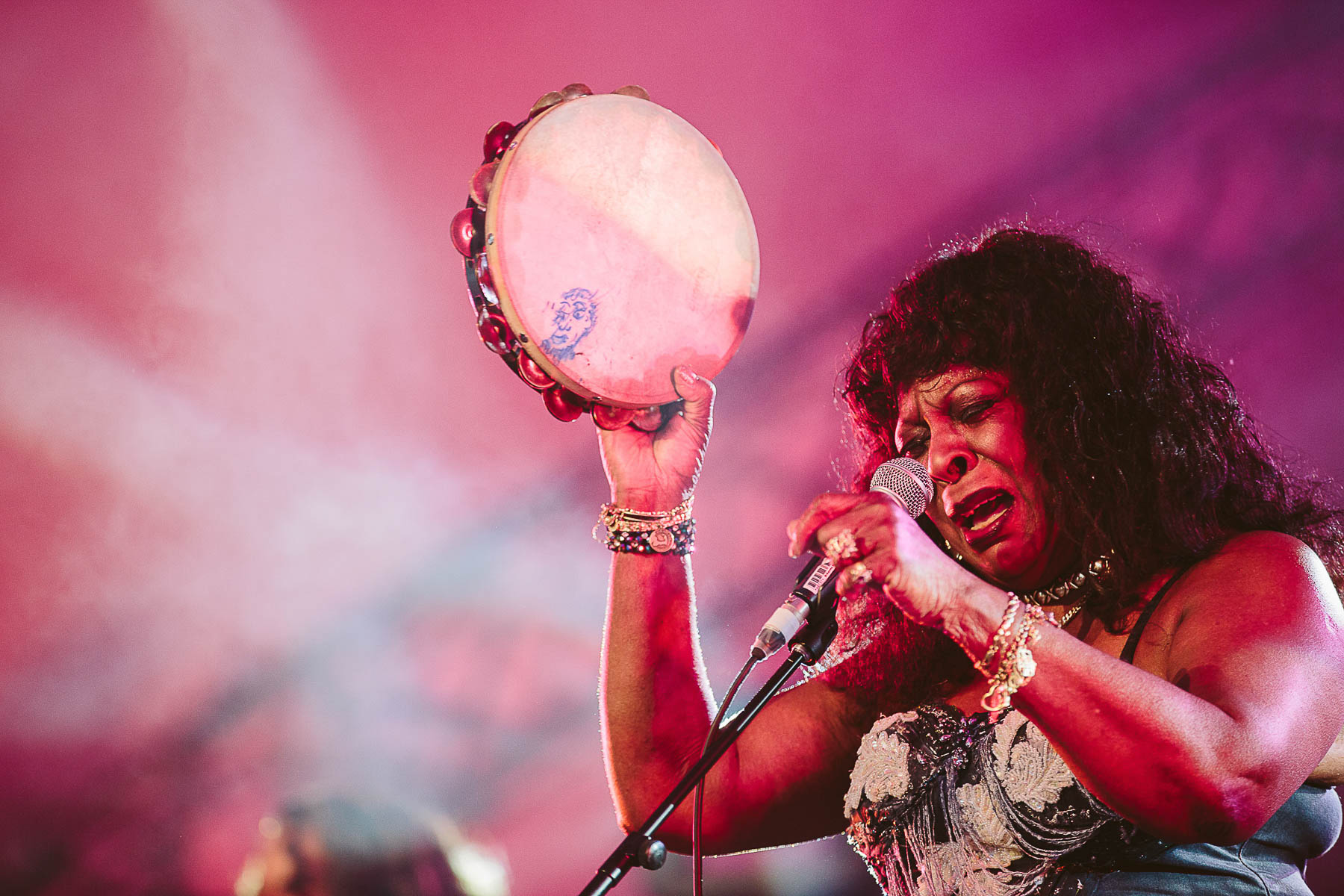 martha reeves holding up a tanbourine on stage