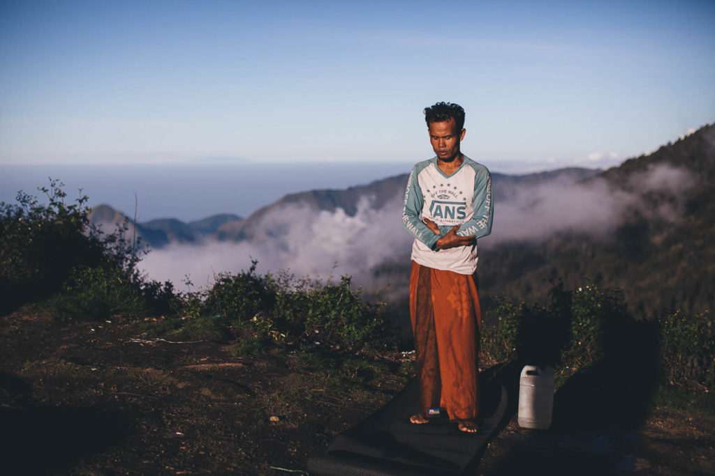 man prays on top of mount rinjani