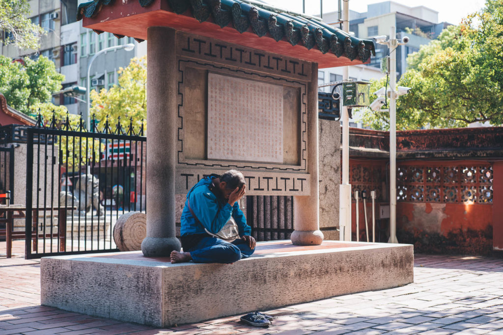 man has head in his hands in taiwan park
