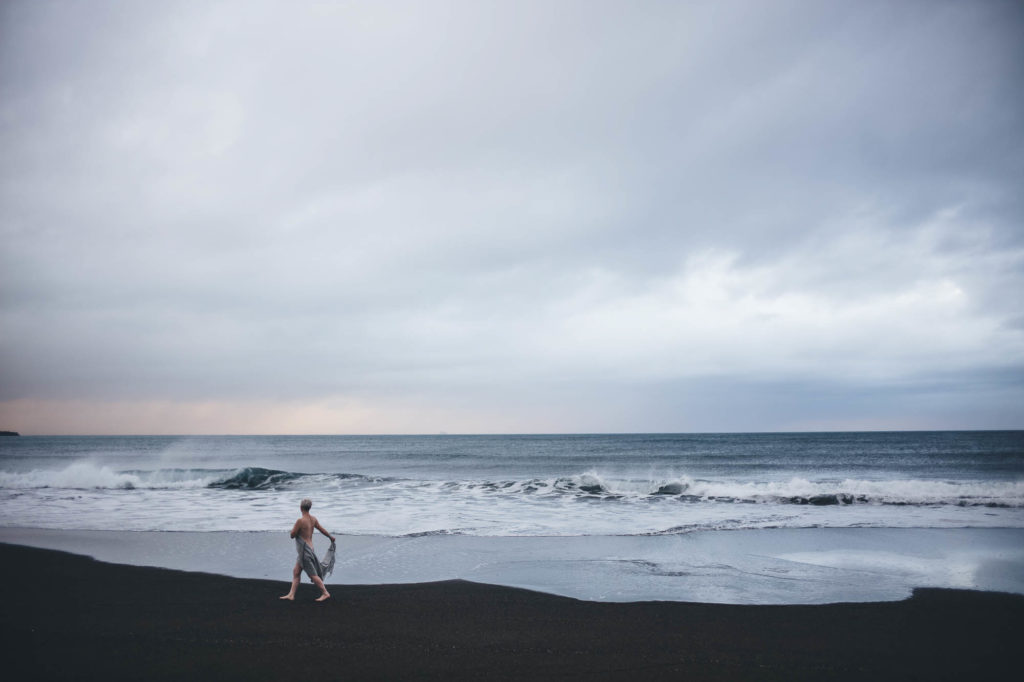 wide shiot on a beach of woman walking