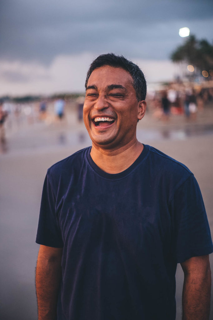 man laughing on a beach