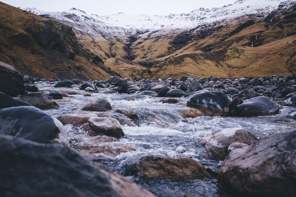 iceland river and snow capped mountains