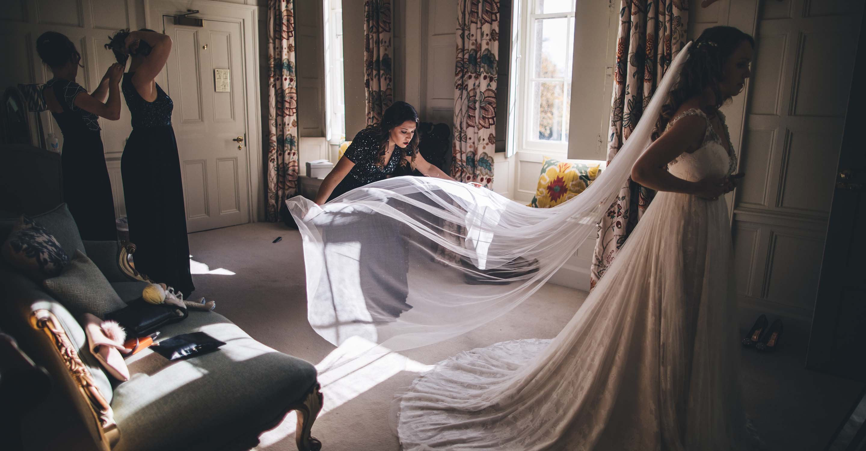 bride being prepared with the help of her bridesmaids