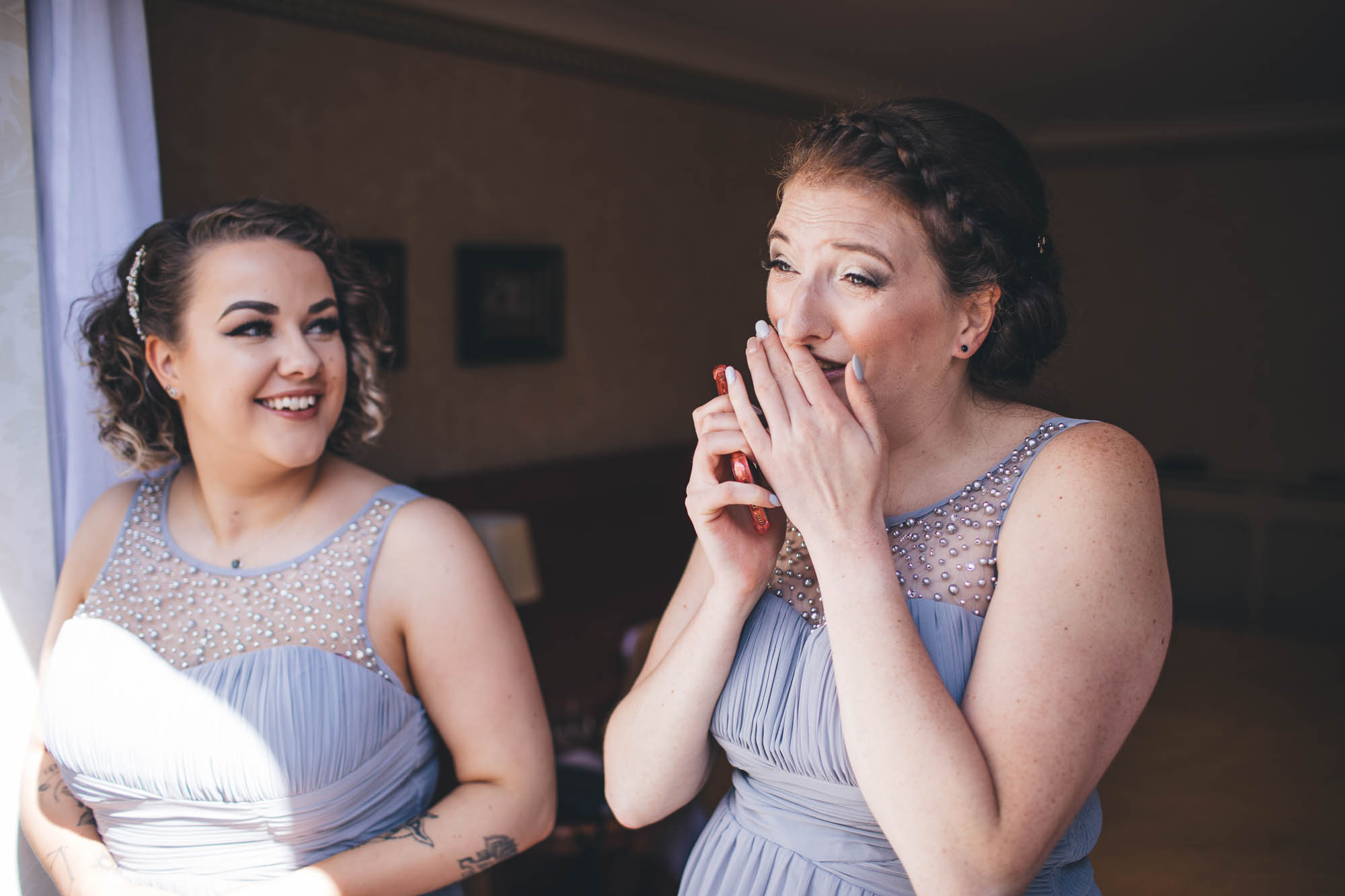 Bridesmaid gets emotional during bridal preparations whilst another Bridesmaid smiles