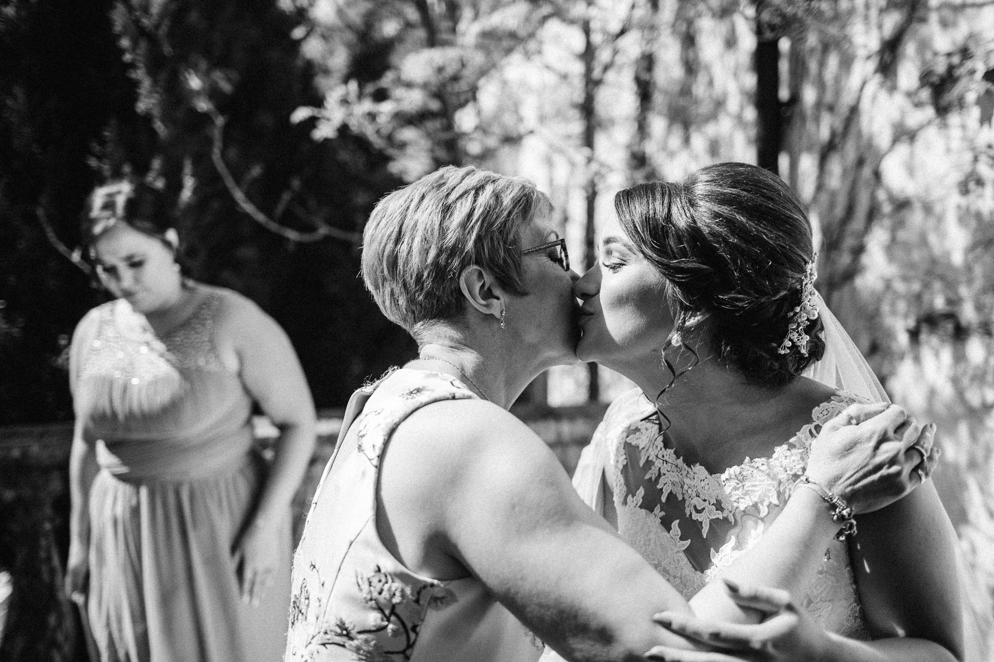 Black and white shot of Mother of Bride and Bride embracing outside during bridal preparations