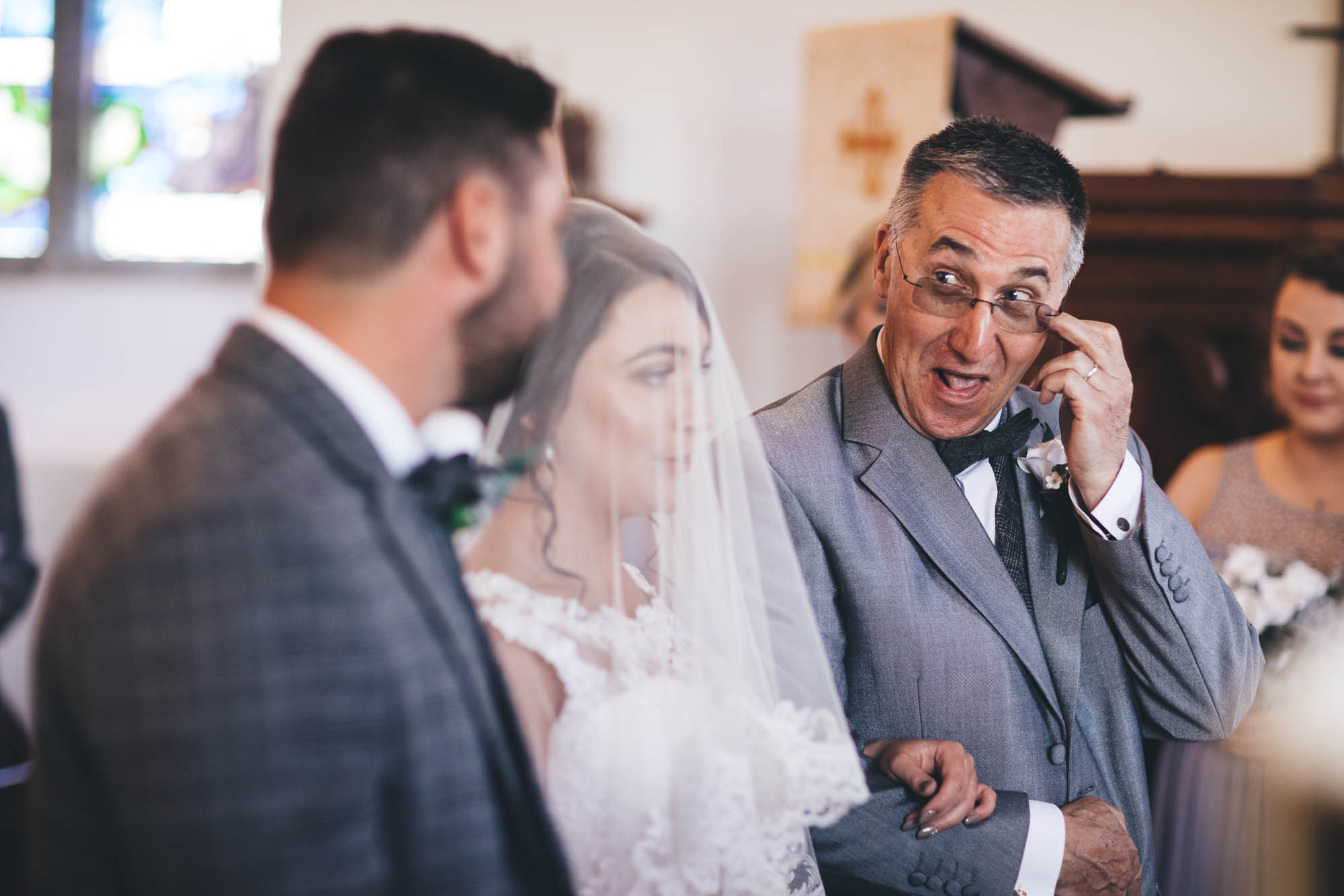 Father of the Bride gives Groom a knowing look as he arrives at the altar with his daughter