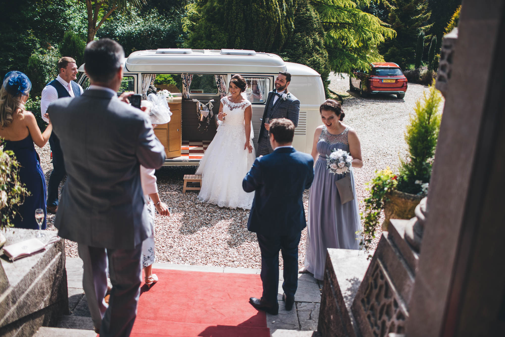 Just married couple are greeted by guests as they arrive at wedding reception
