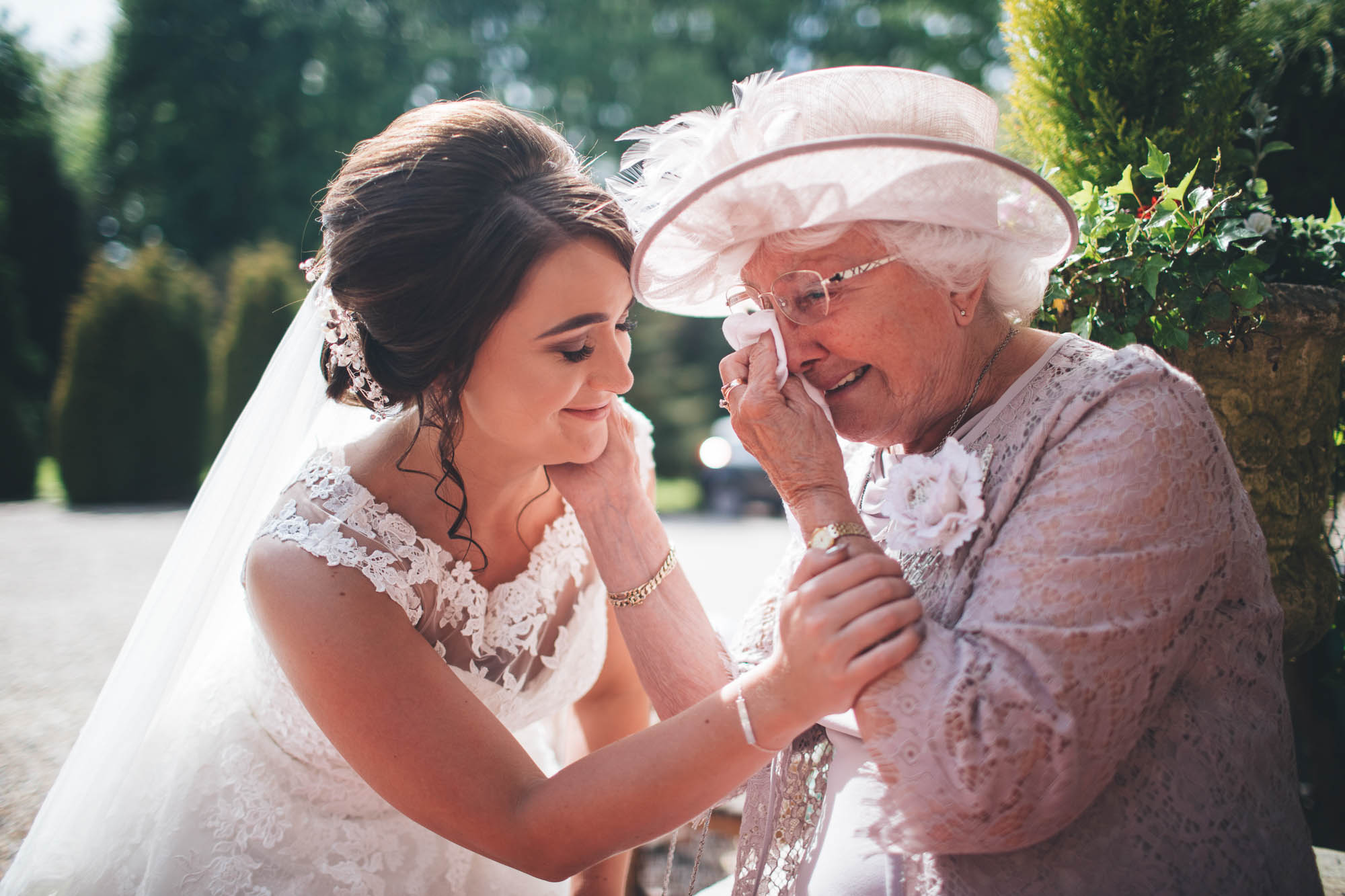 Bride and Grandmother share an emotional moment on Wedding day as Grandmother wipes tears away