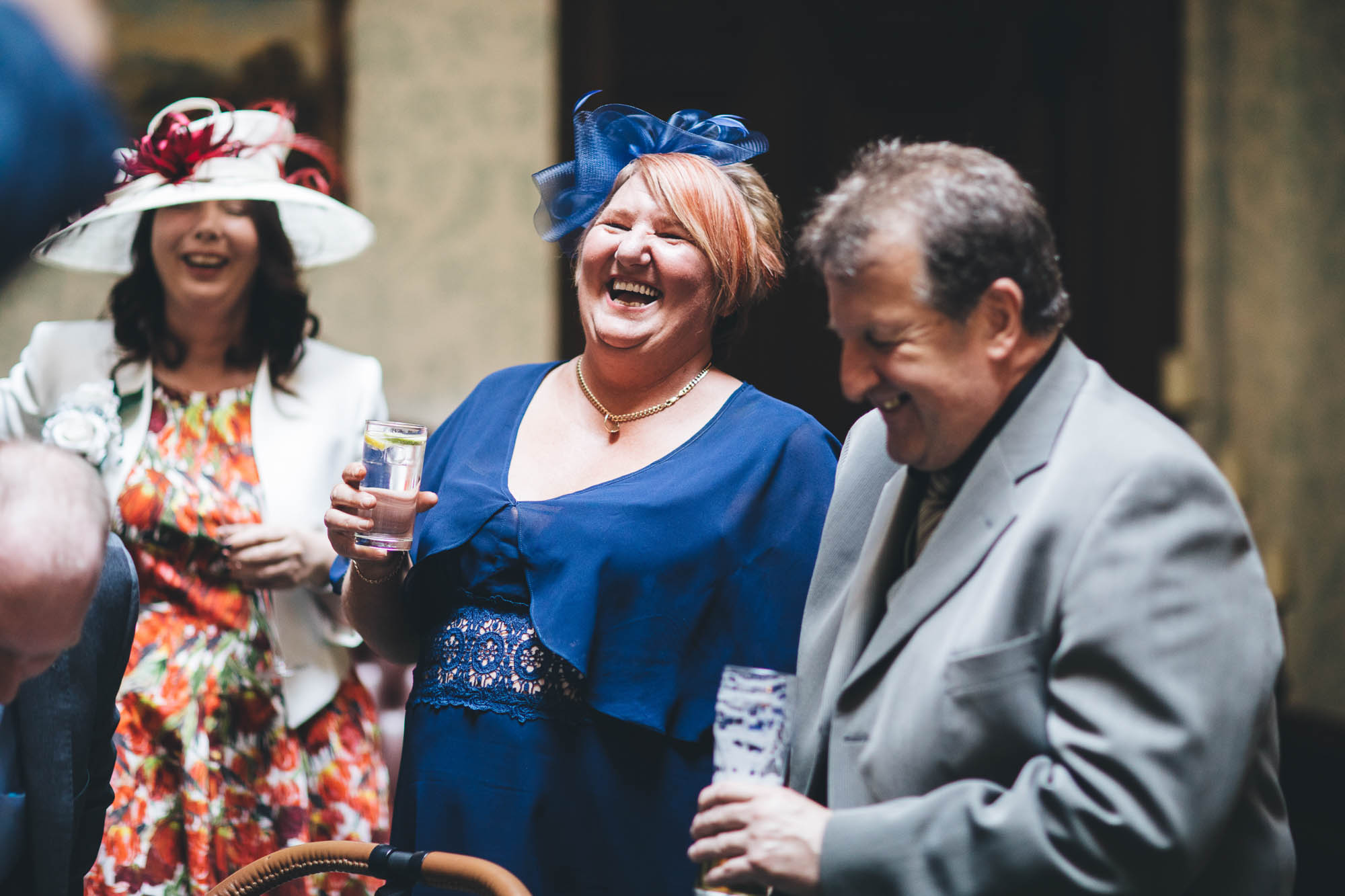 Wedding Guests share a joke while they have a drink at wedding reception