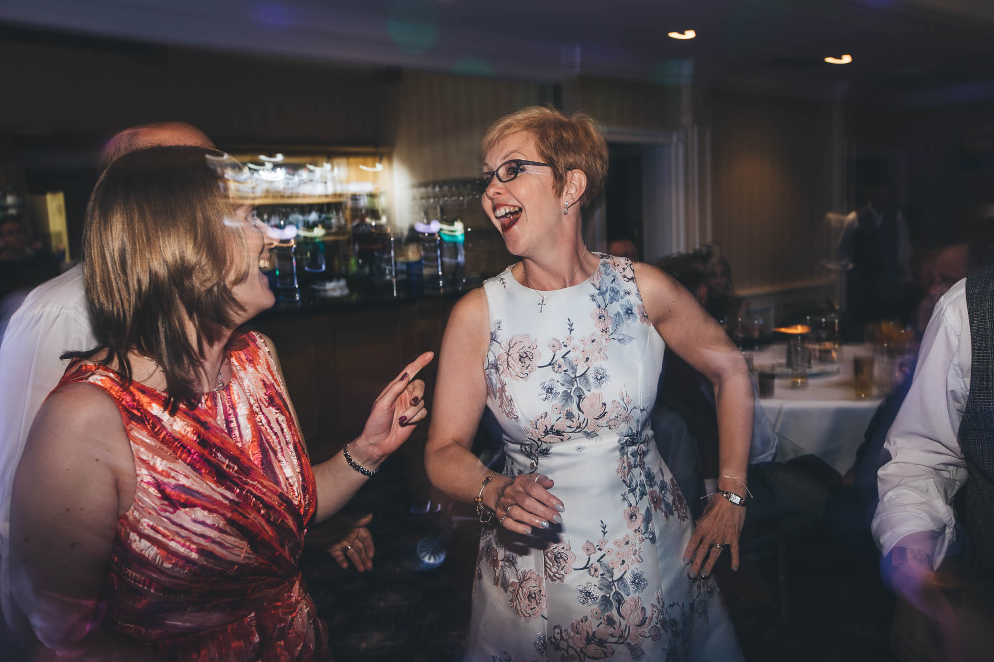 Mother of Bride laughs and dances at wedding disco with guests
