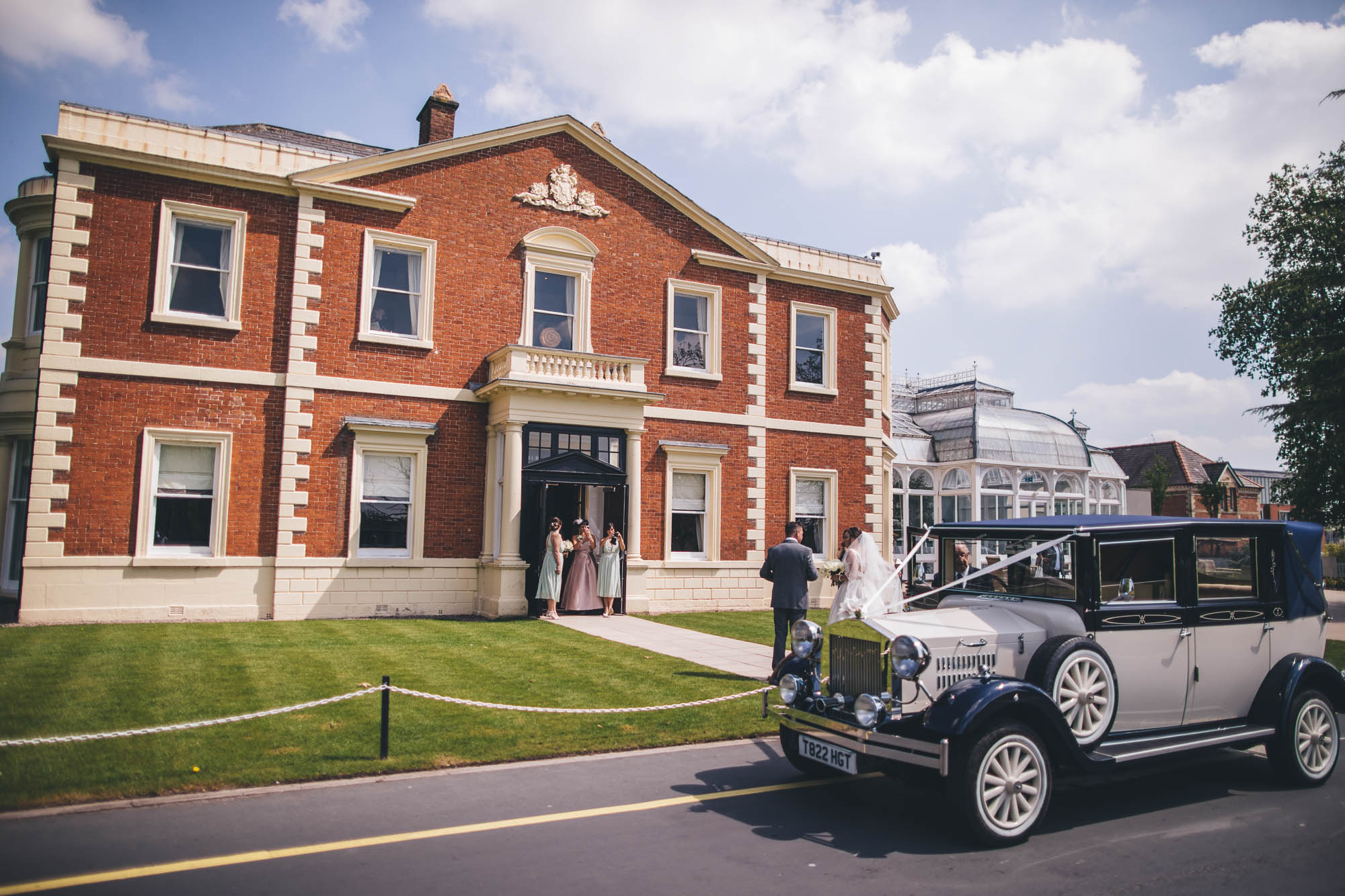 Wide Angle shot of Bride entering 17th Century Manor House Hoole Hall on wedding day