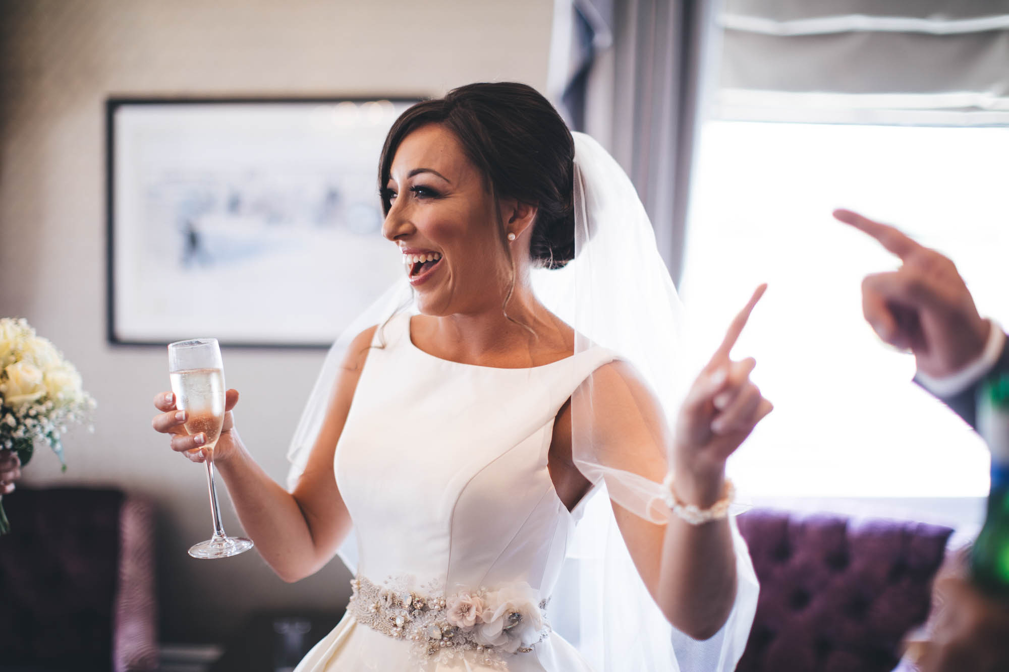 Bride dancing and having a glass of bubbly on the morning of her wedding