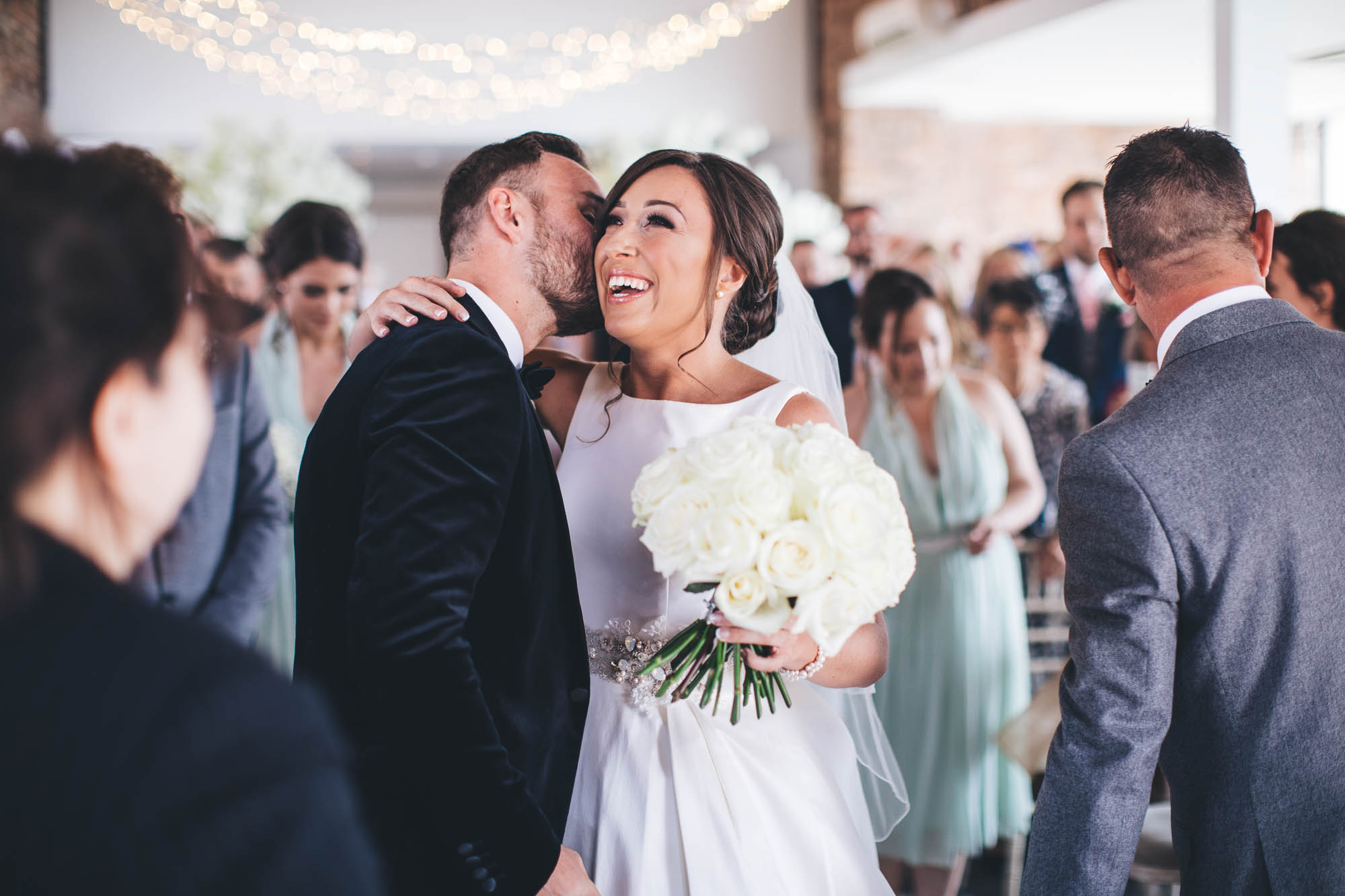 Groom greets Bride with a kiss on the cheek at the altar
