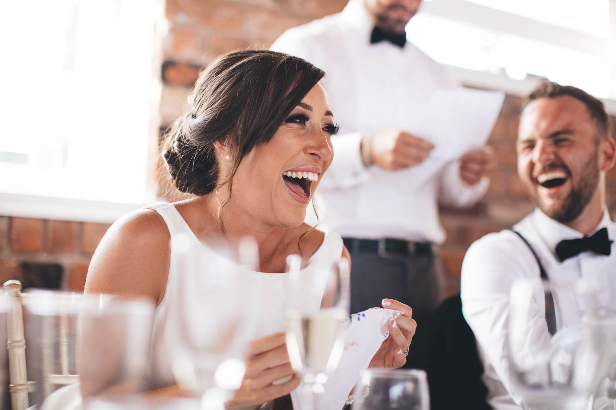 Bride laughs uncontrollably while Best Man does his wedding speech