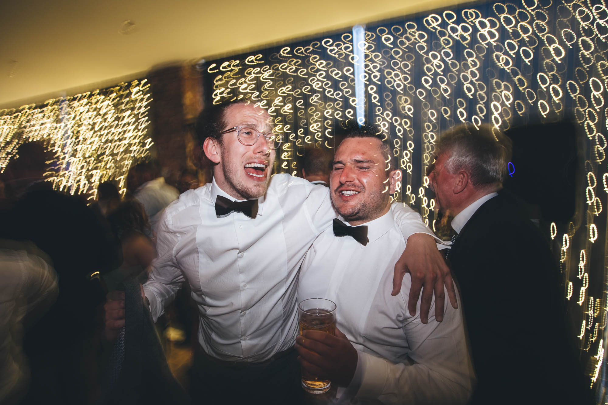 Groomsmen get rowdy singing with pints at wedding reception