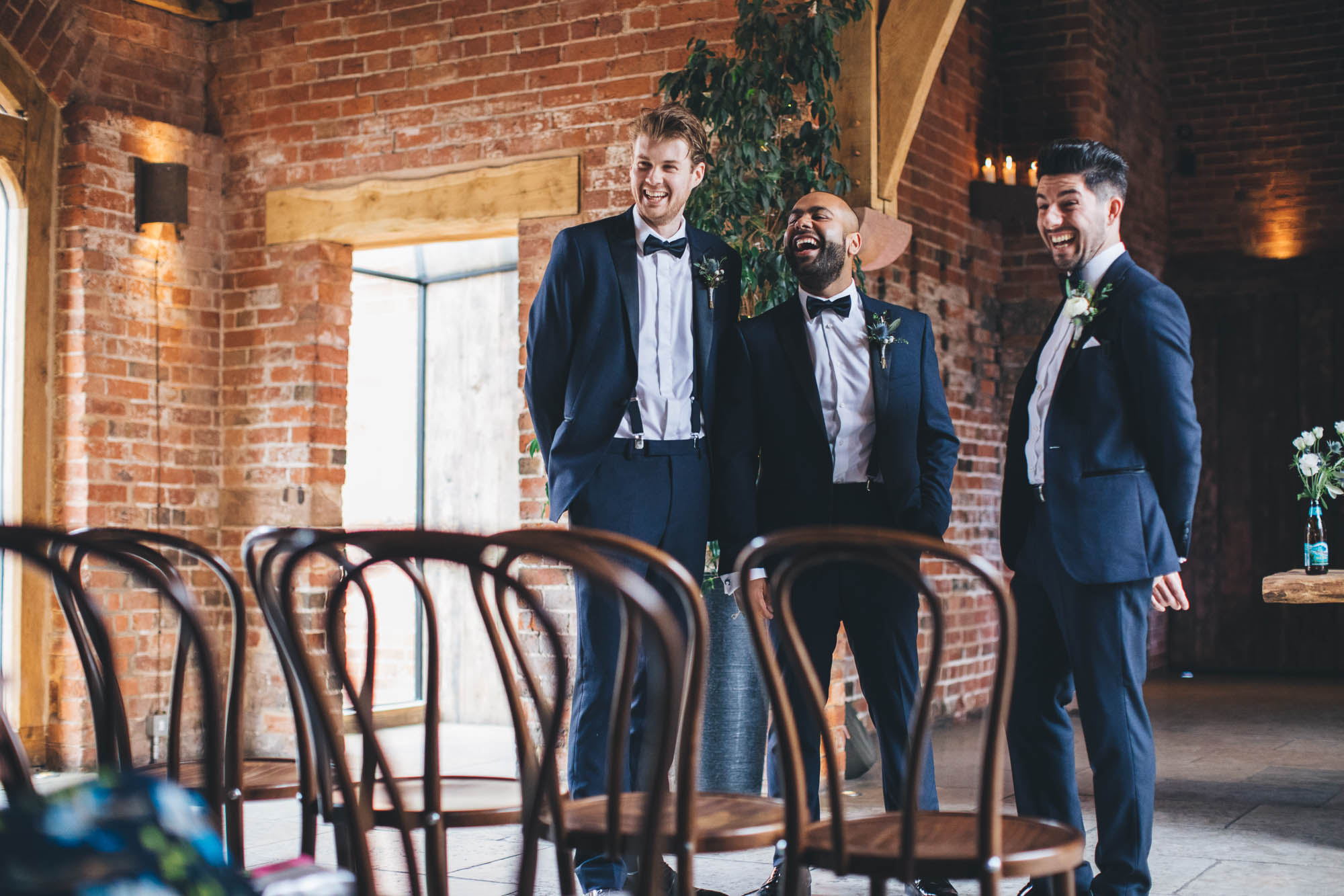 Groomsmen laughing whilst waiting for guests to arrive