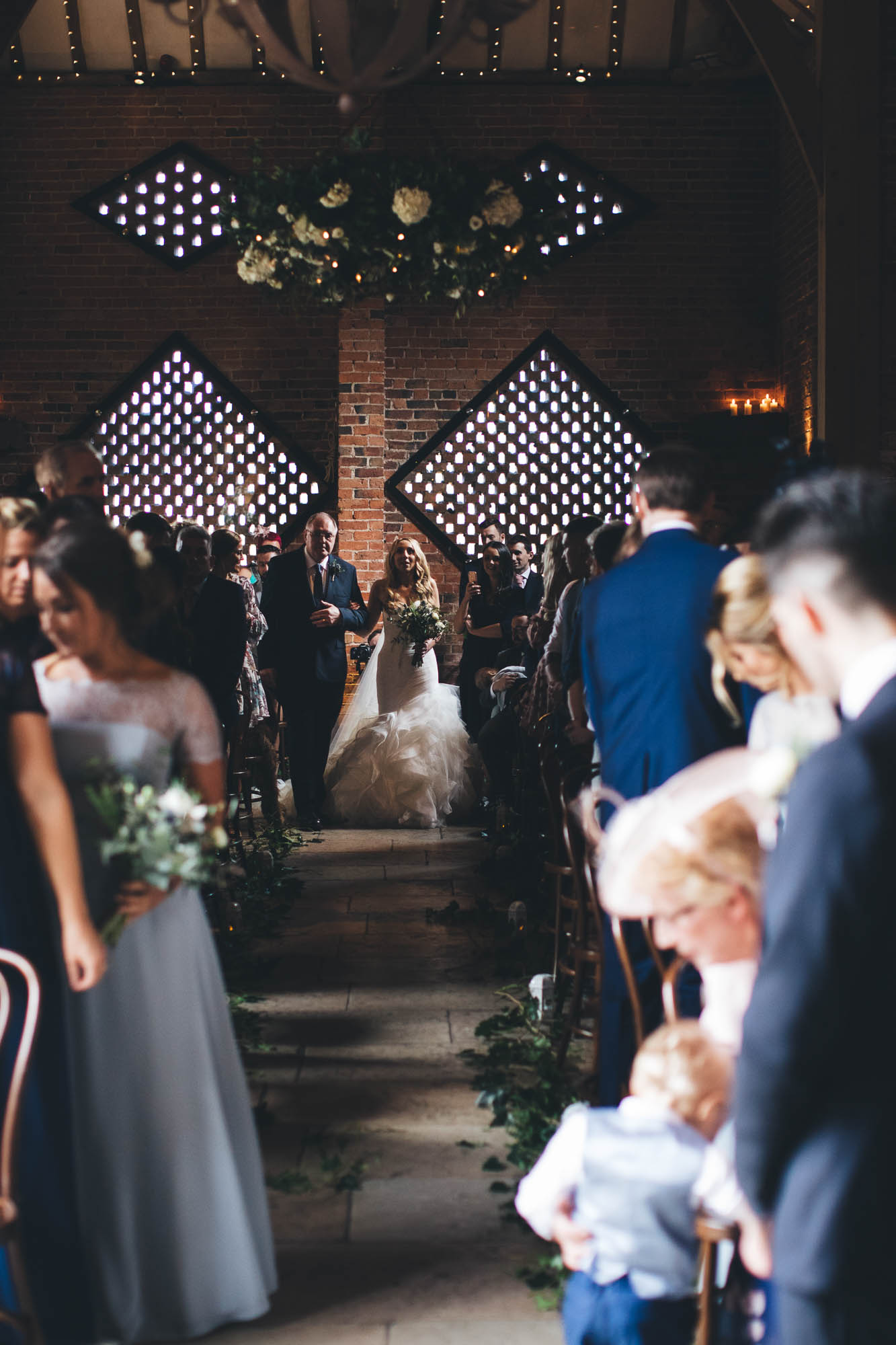 Father and Bride start to walk down the aisle as guests start to turn and look