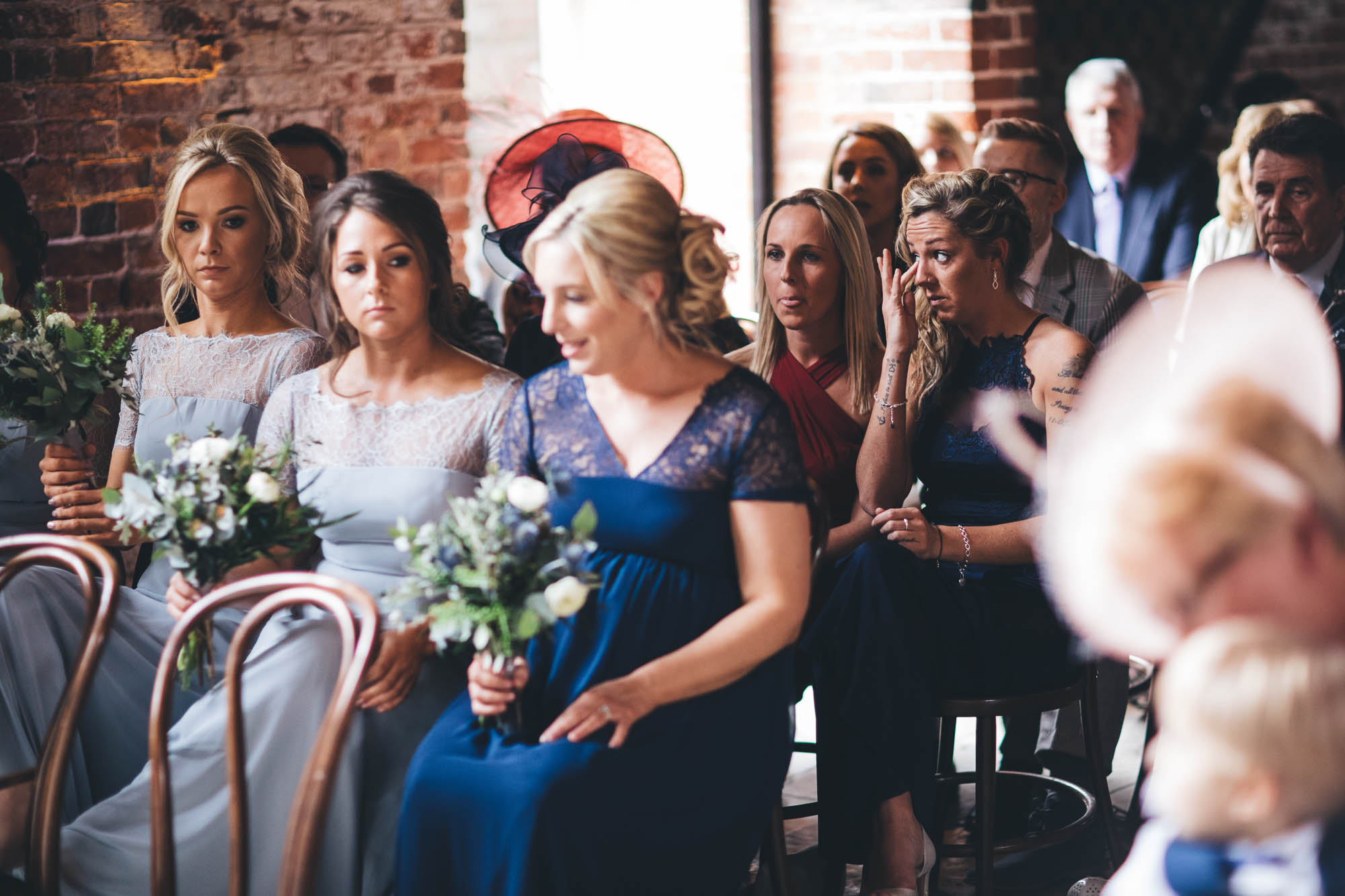 Wedding guests in a red brick rustic barn