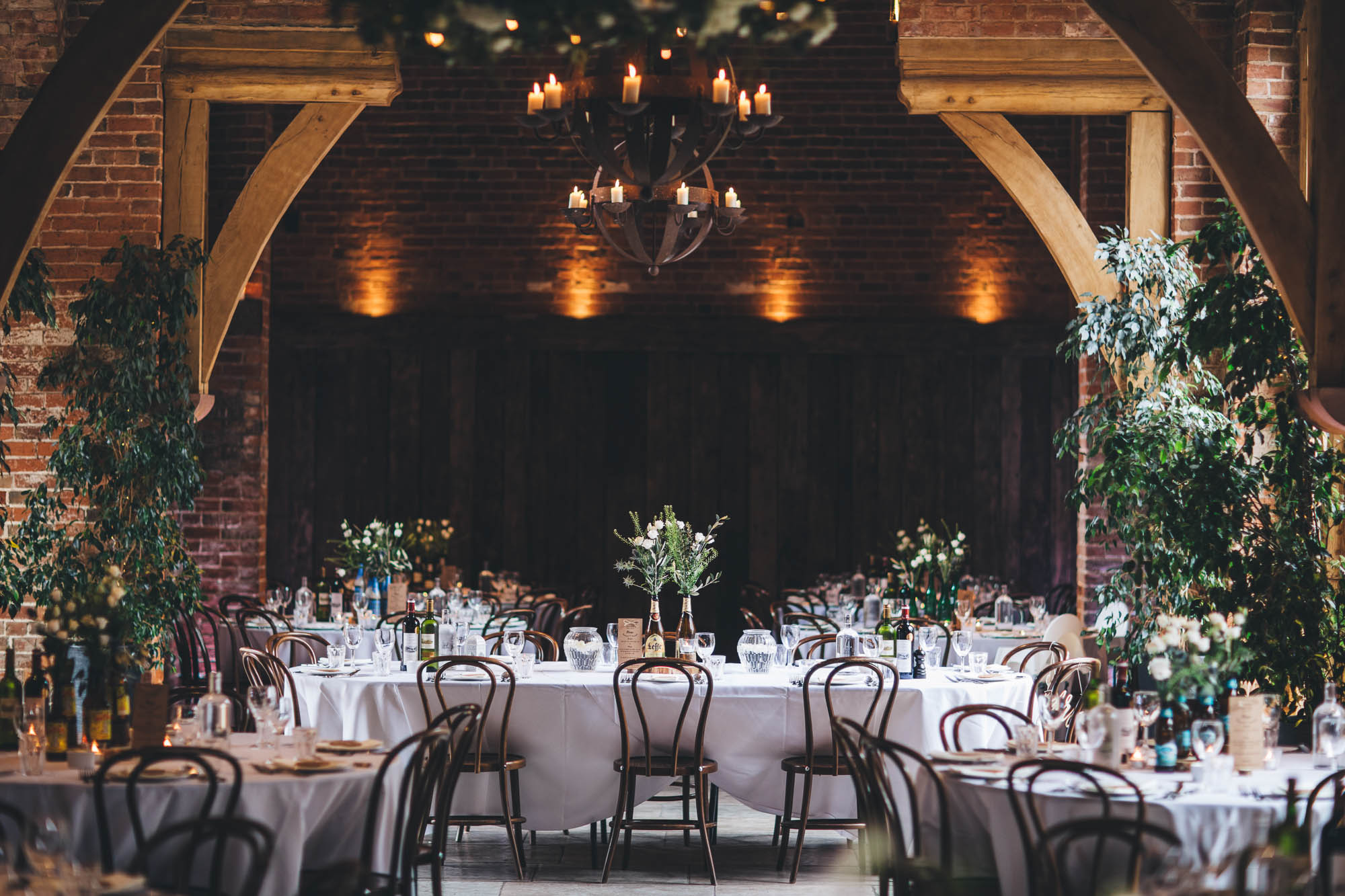 Wedding reception in rustic red brick barn with candlelight
