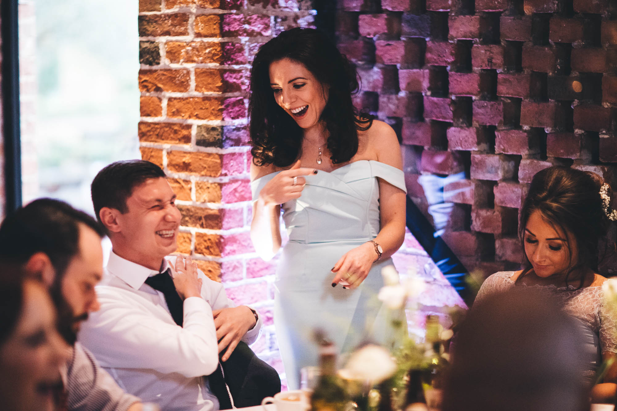 Wedding guest stands up as she is told a joke at reception dinner