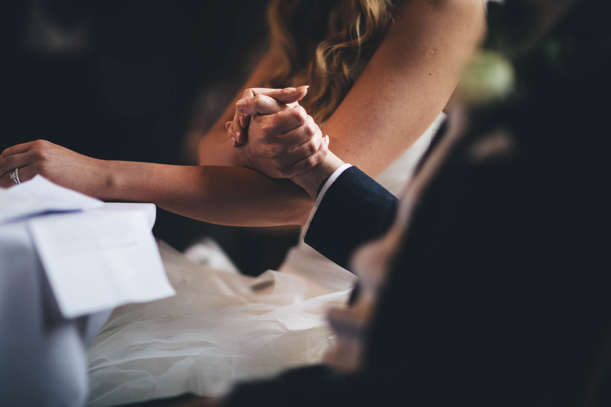 Bride and Groom hold hands during wedding speeches