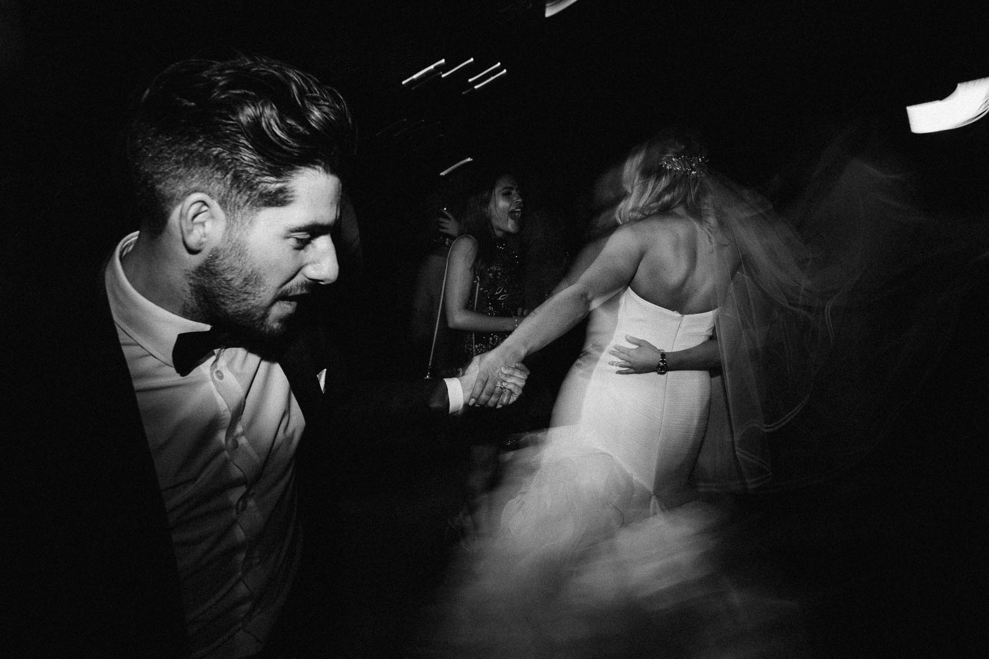 Black and white shot of bride and groom swinging about on the dancefloor