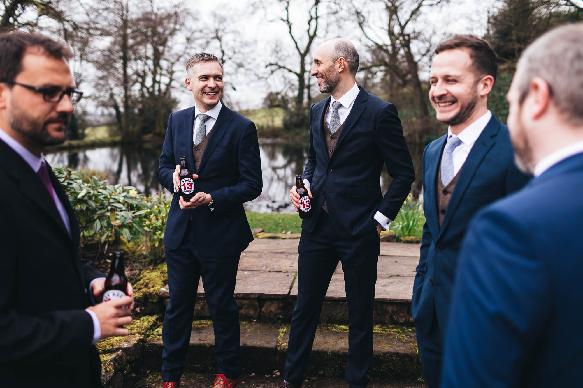 Groomsmen share a beer outside in the morning before wedding ceremony