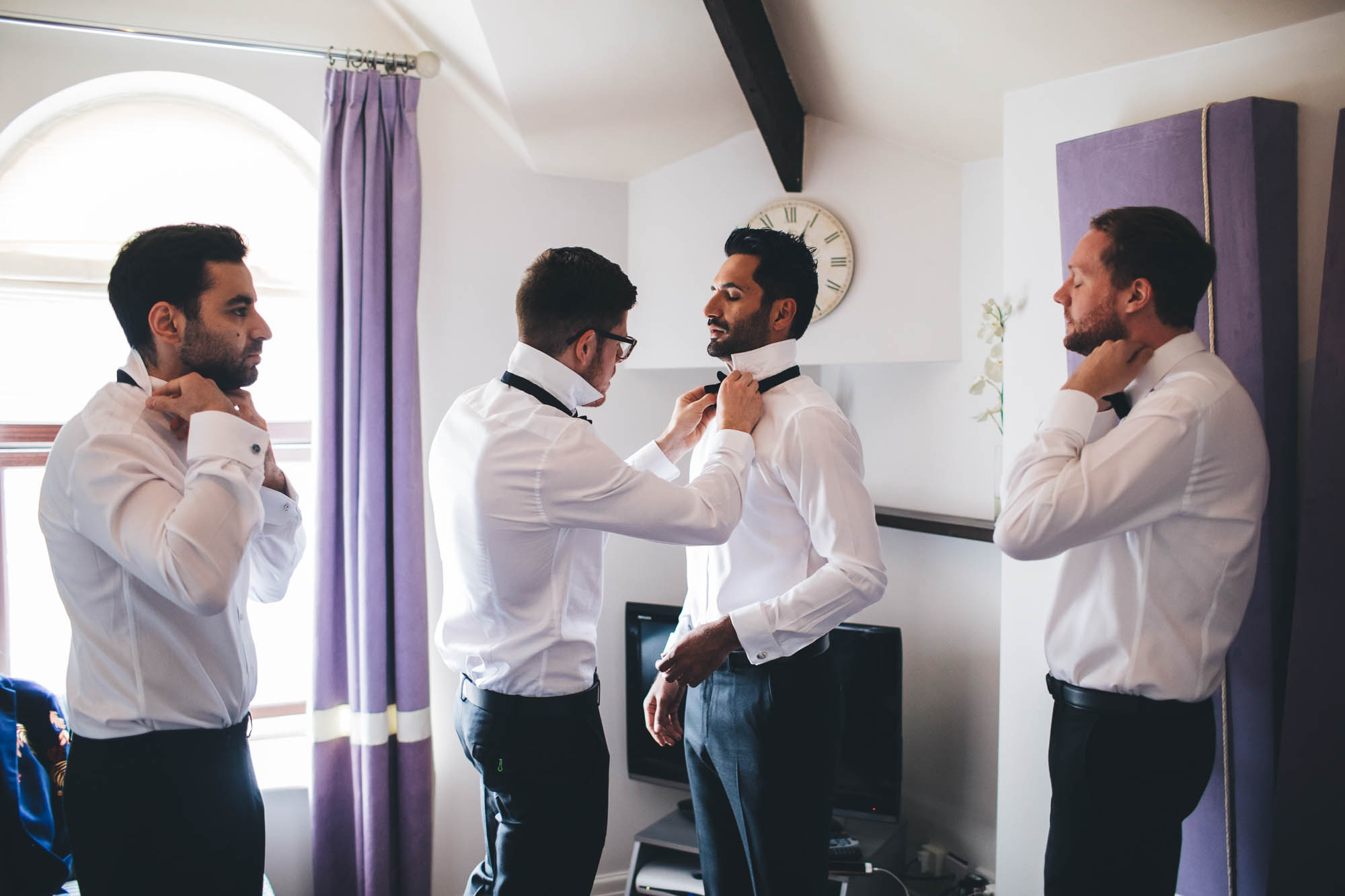 groomsmen doing their shirts up