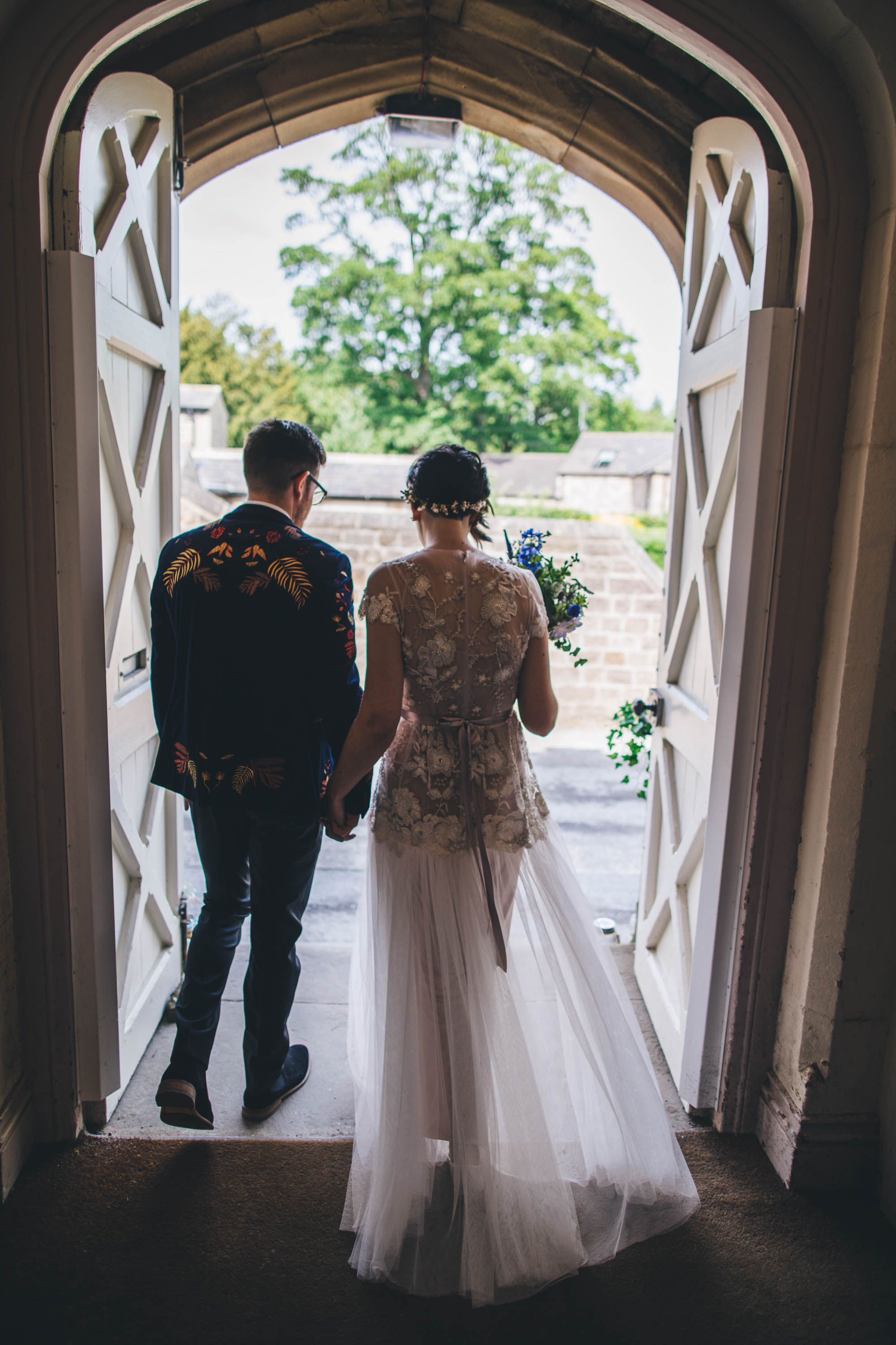 couple shot from behind on their way out after the ceremony