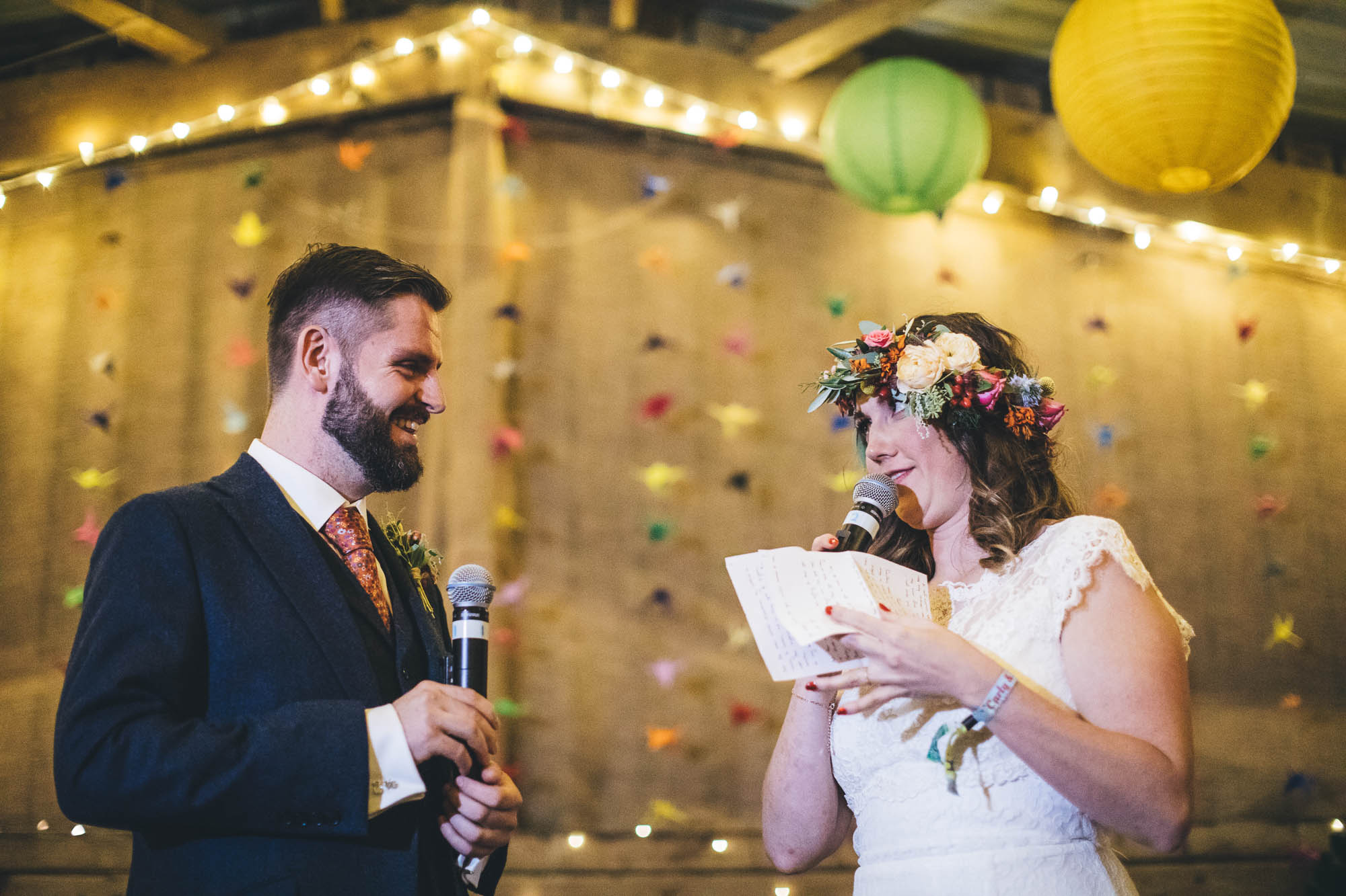 bride and groom hold microphones as they address their guests during the wedding breakfast