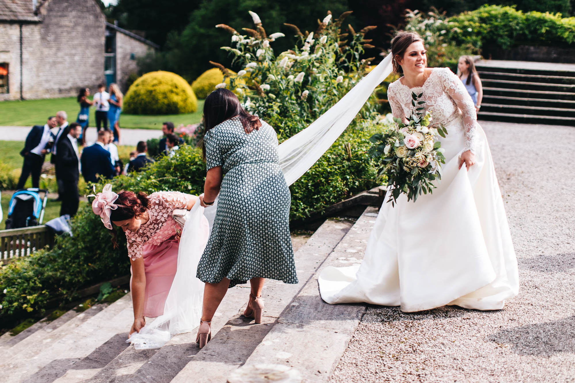 bride is rescued by friends as her veil gets caught on the steps