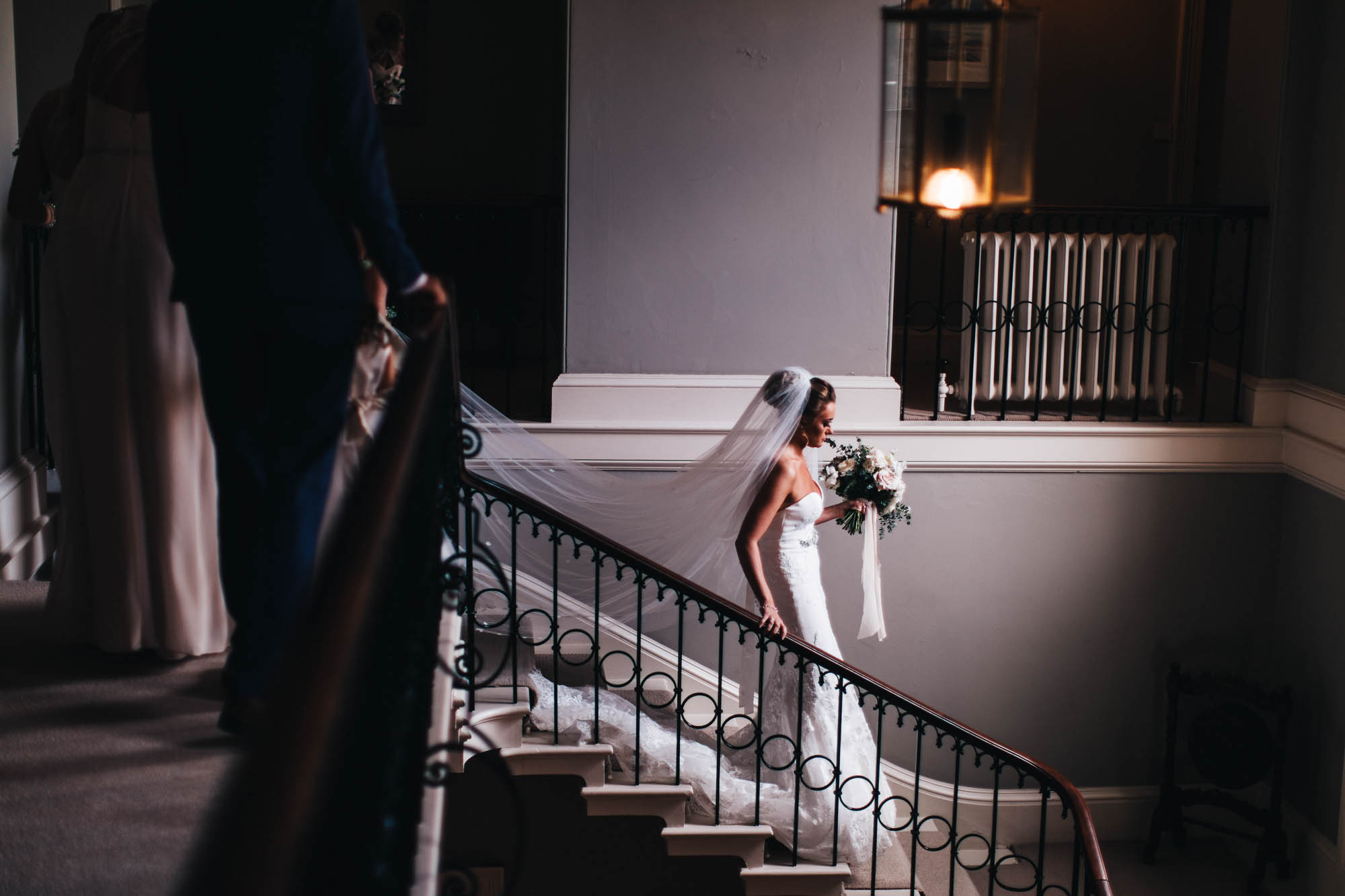 bride walks down stairs in some beautiful window light