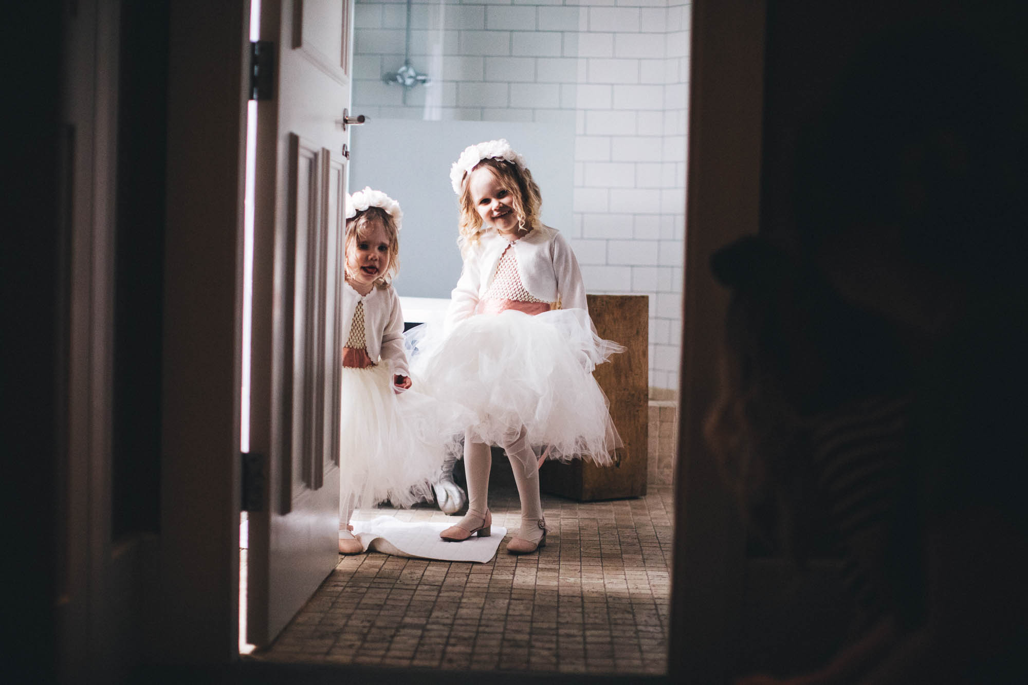two flower girls looking cheeky in the bathroom