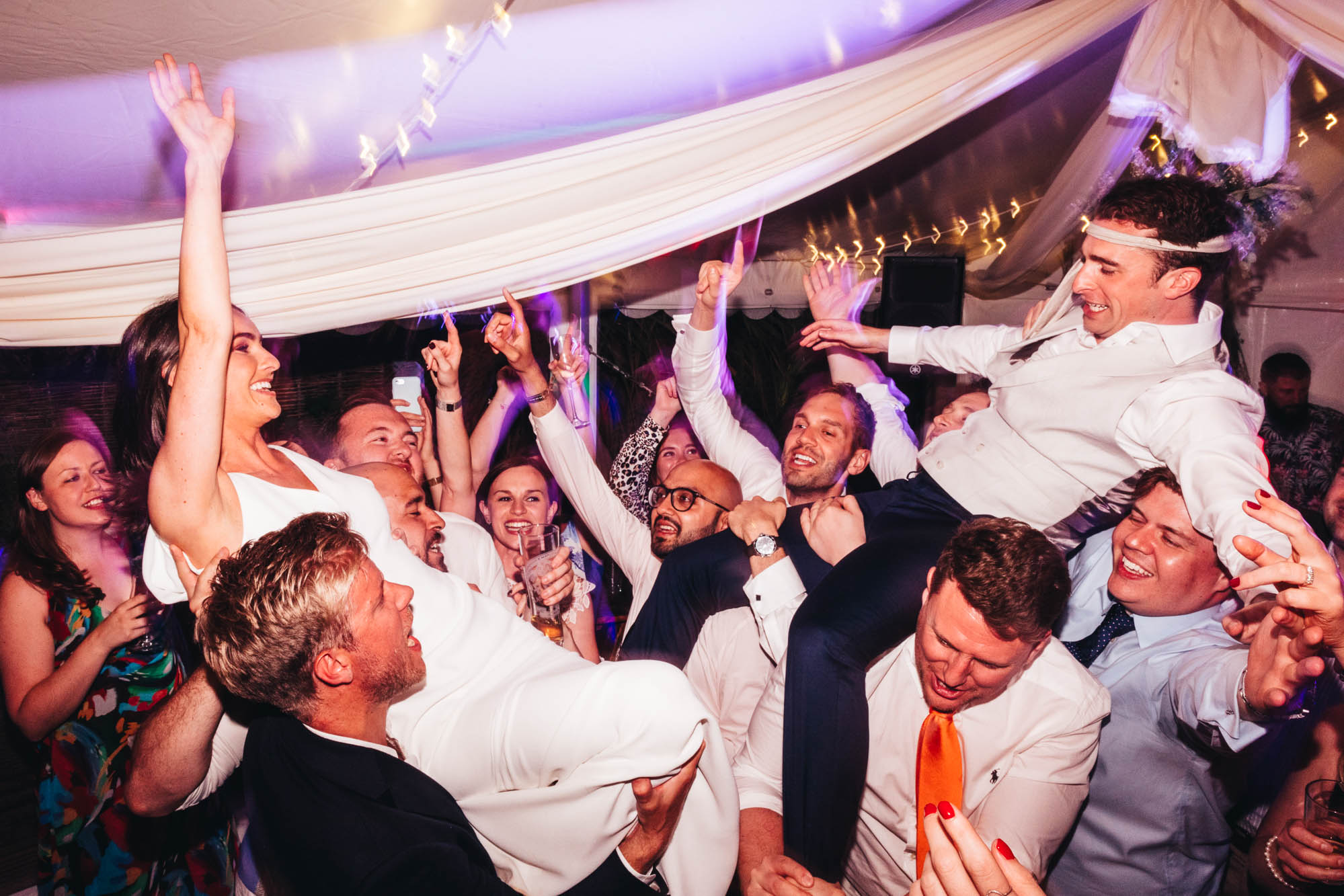 couple are raised up by their guests on the dancefloor