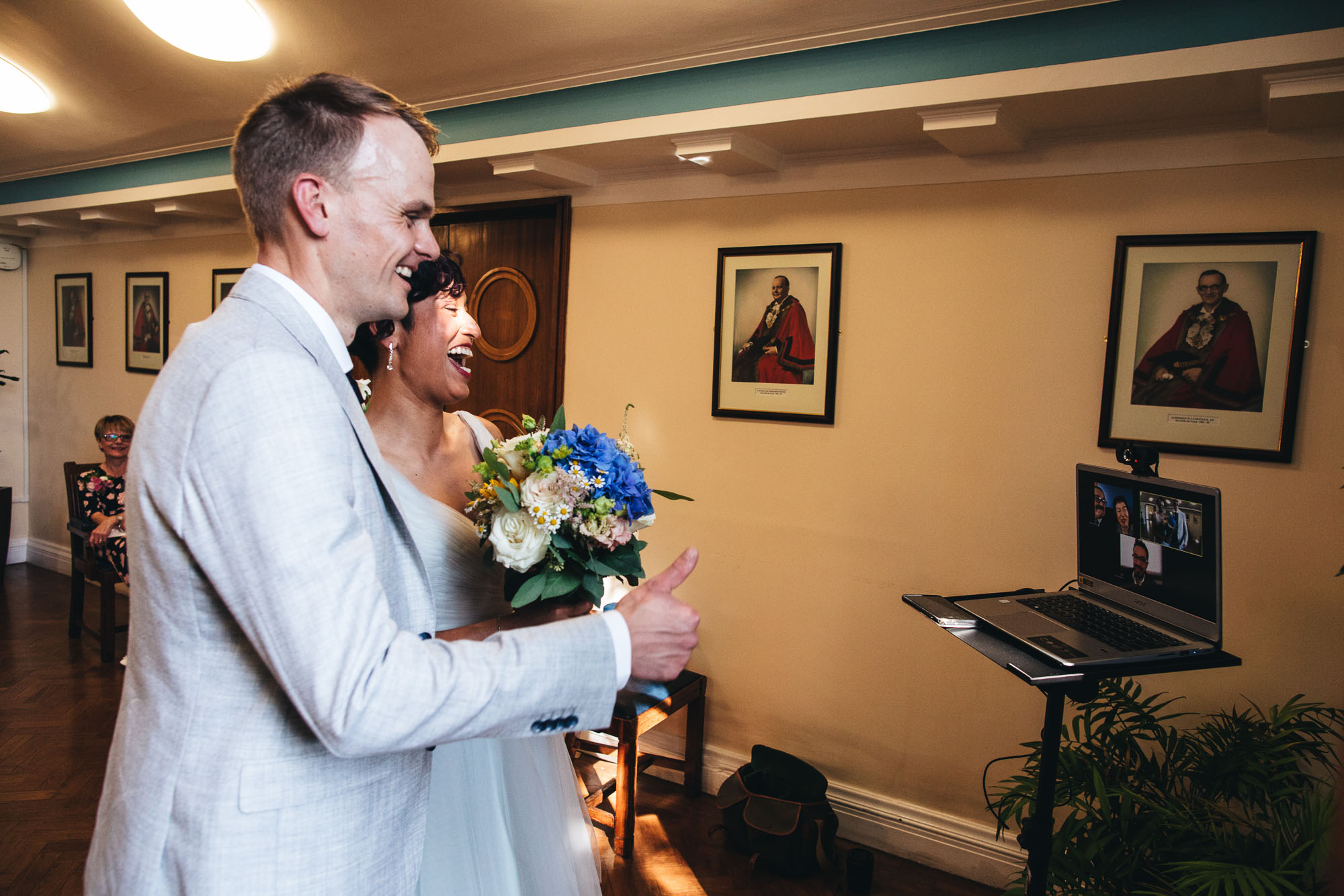 couple chat with family via a zoom call during the ceremony